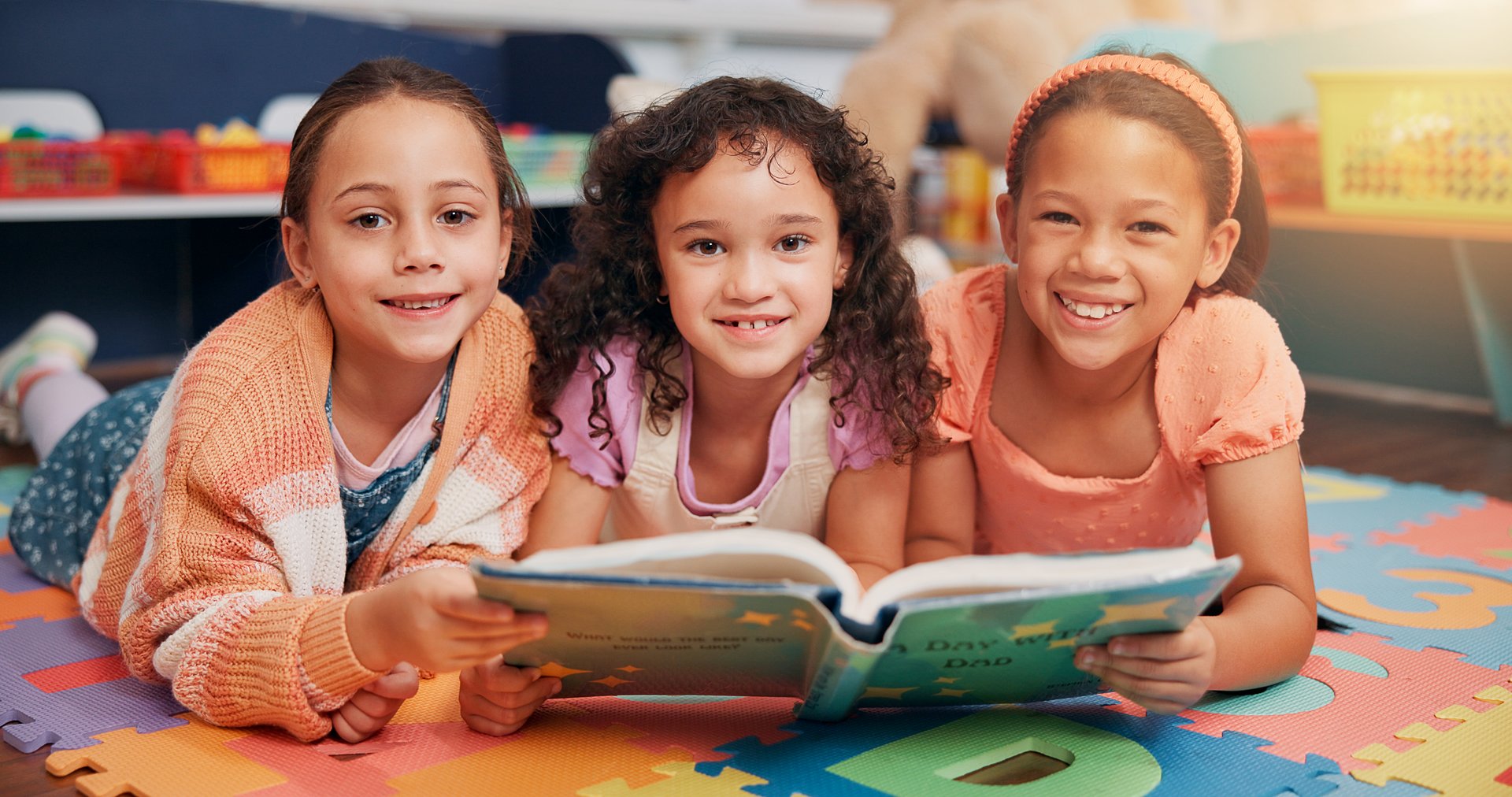 School kids, group and portrait on floor with reading book, learning and smile together with diversity for education. Children, happy and friends with literature, development and study at academy