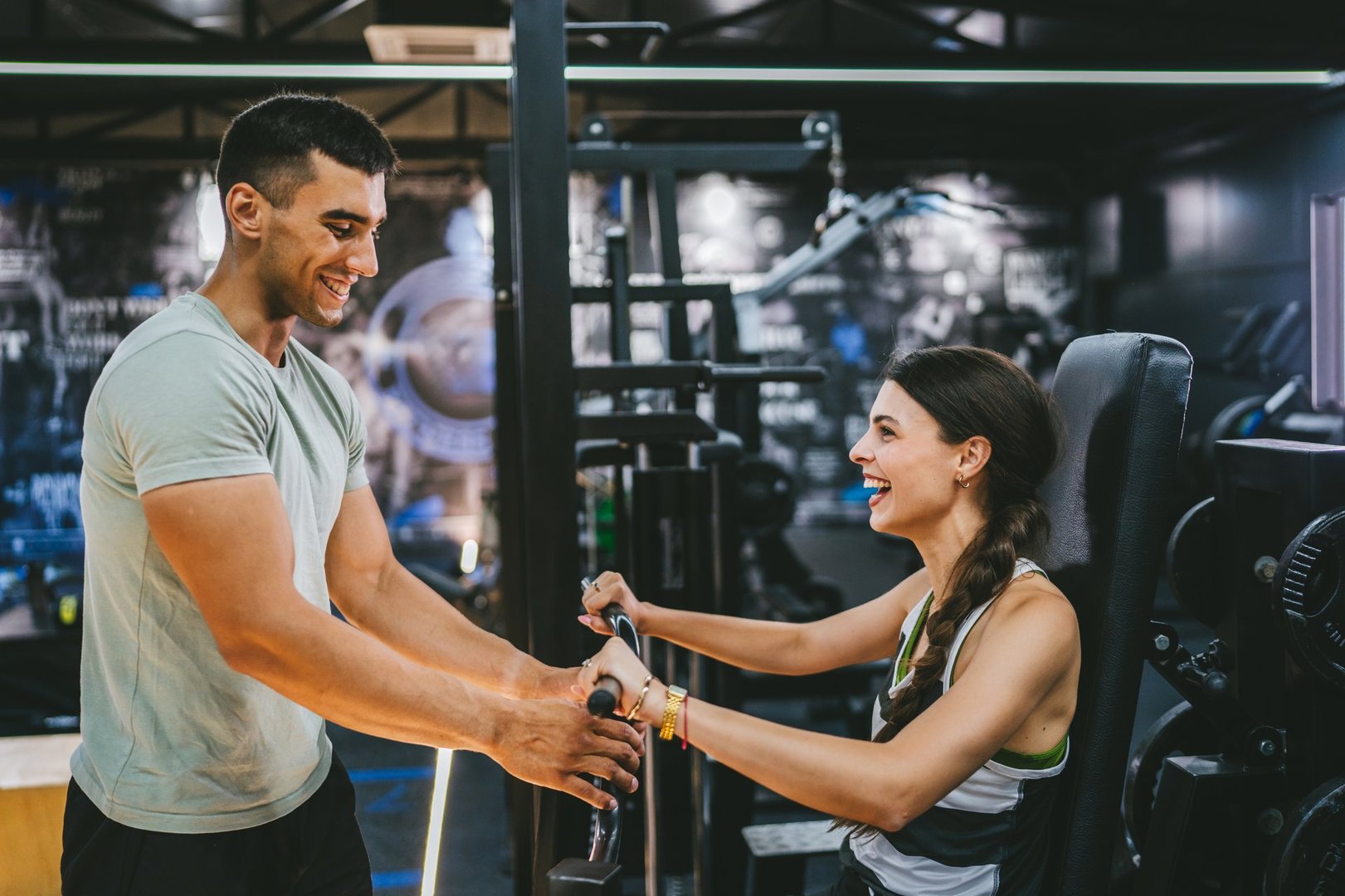Adult sports woman doing chest press exercise with personal trainer at gym