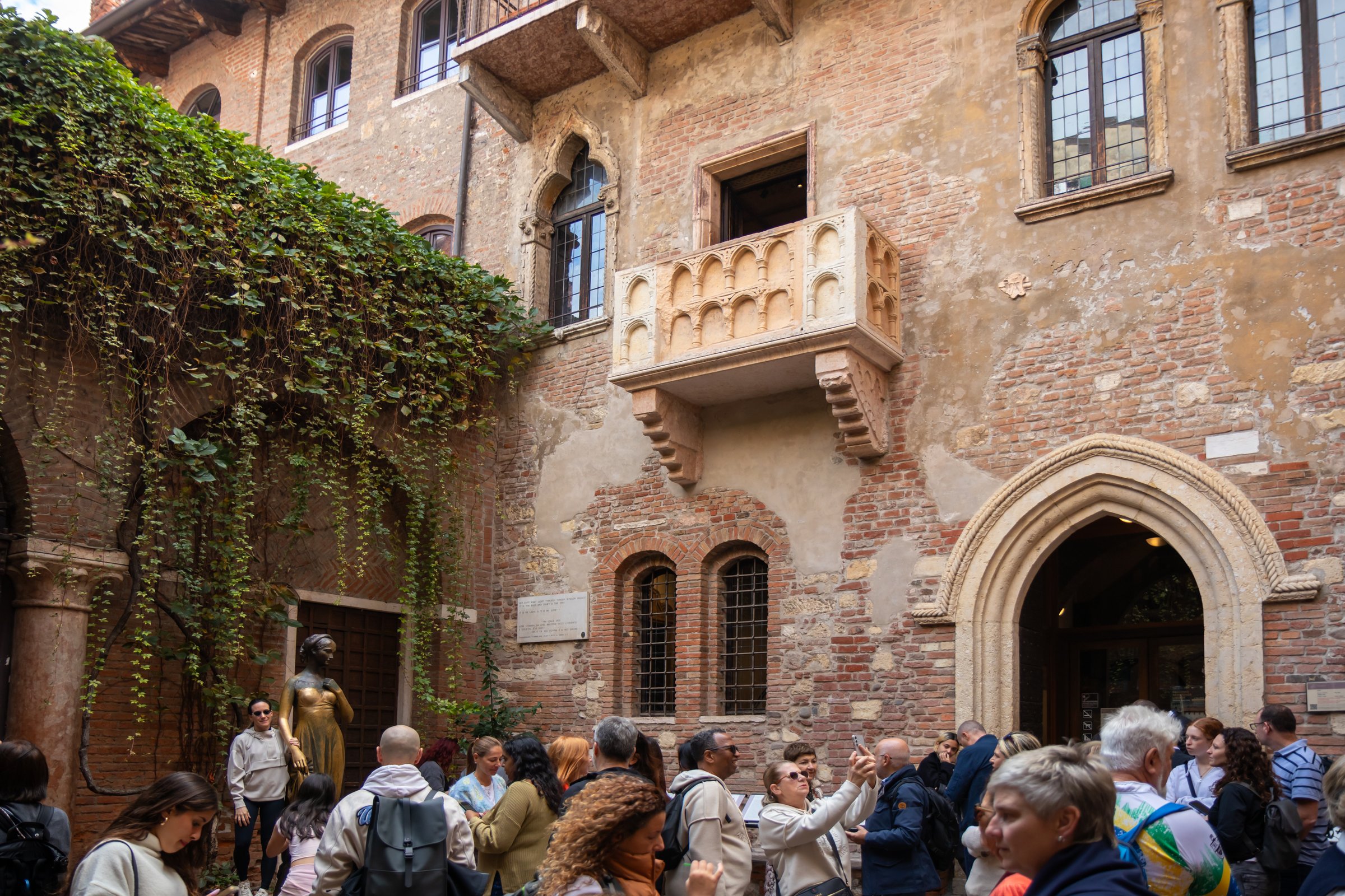 Italy, Verona - October 1st, 2025: tourists gathered near the statue of Juliet below the balcony at Casa di Giulietta, the iconic symbol of love and one of the most romantic landmarks
