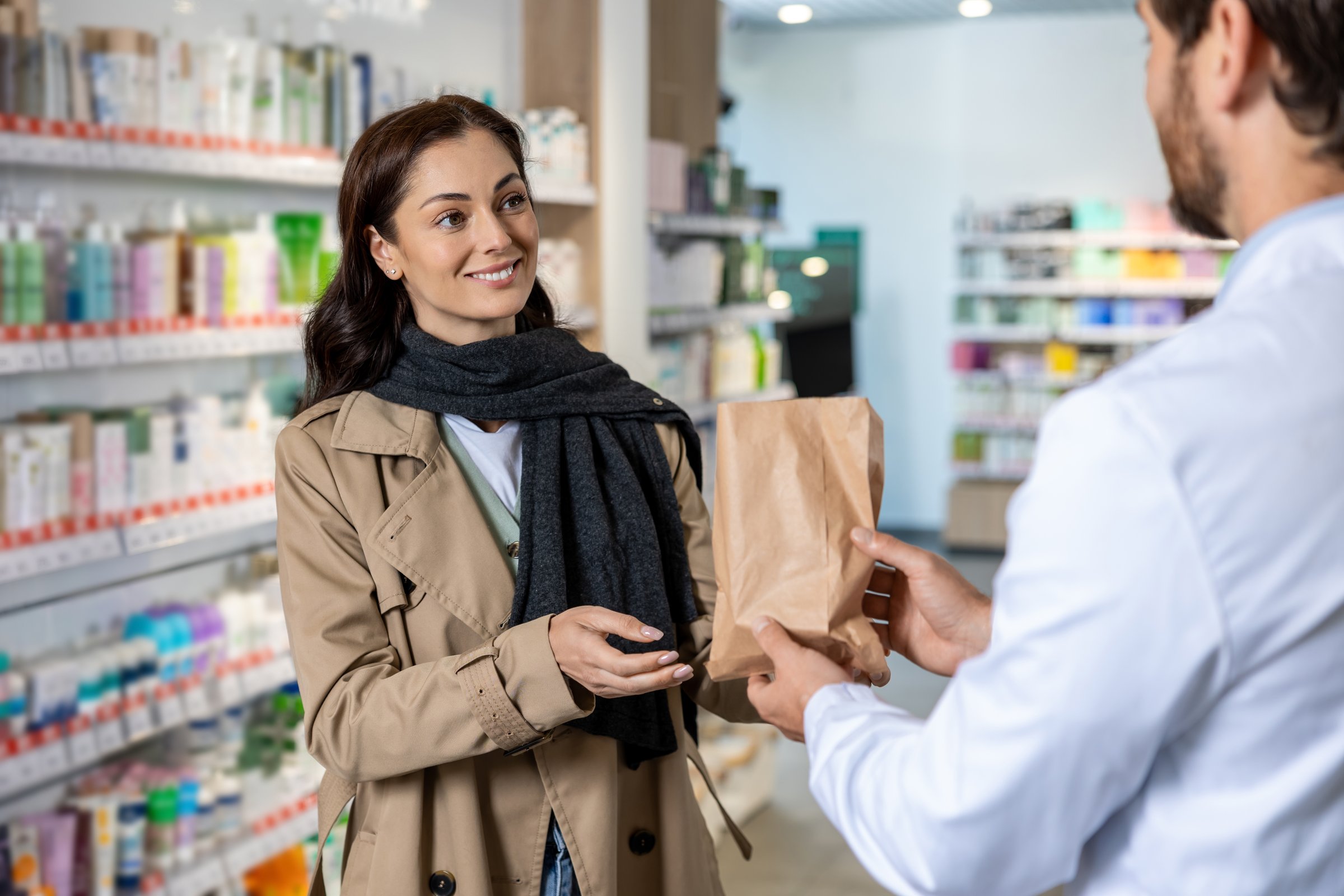 Talking to pharmacist. Dark-haired pretty young woman talking to the pharmacist and looking interested