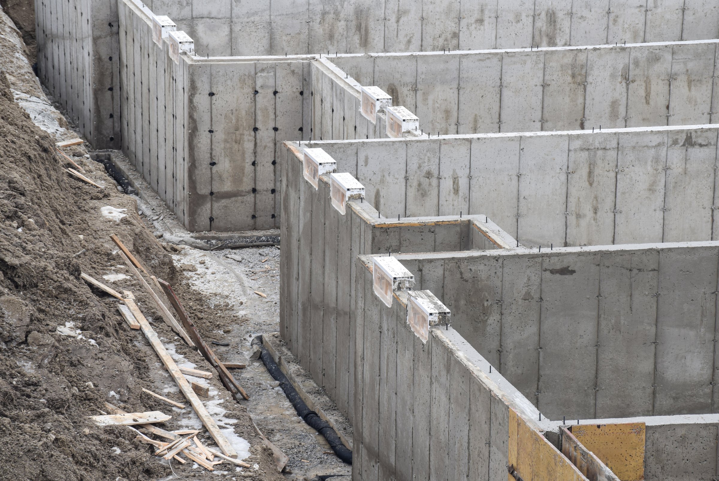 Concrete walls of basement foundation with weeping tile at a construction site