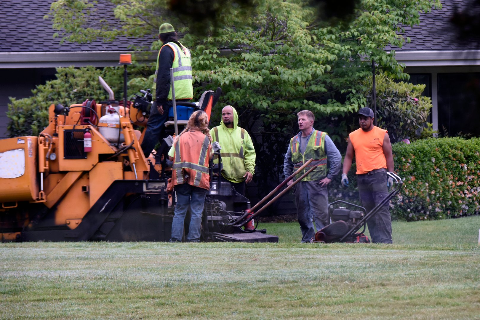Five road repair workers waiting for more asphalt
