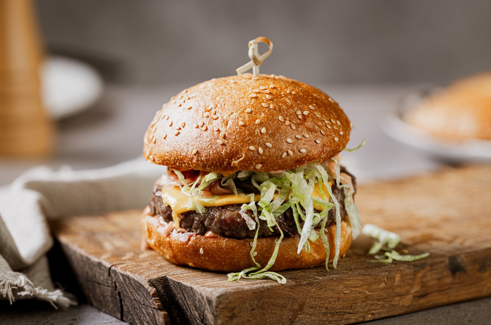 fresh tasty burger on wooden rustic cutting board on restaurant table