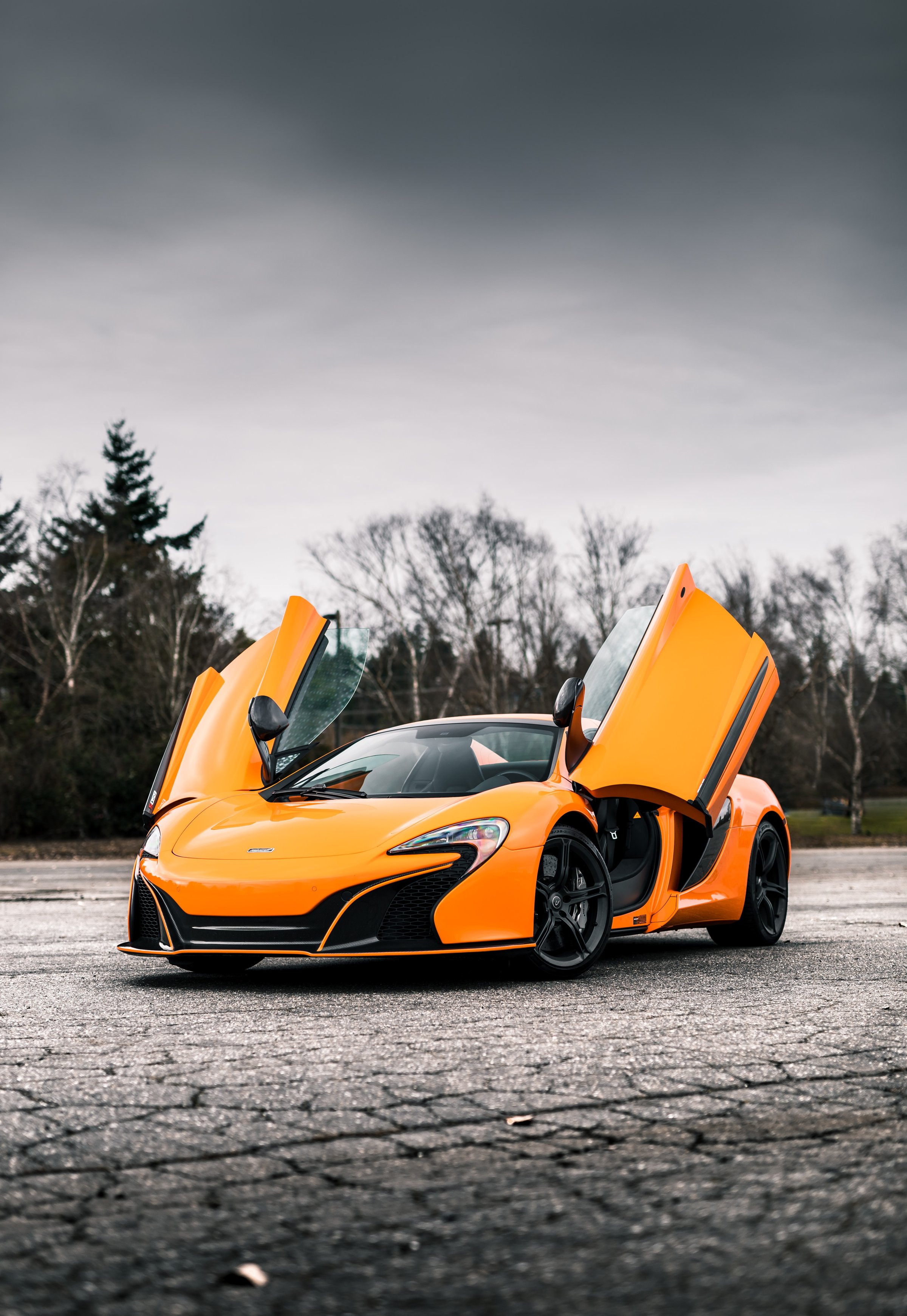 Seattle, WA, USA
1/9/2022
Orange McLaren car parked on asphalt with grey skies overhead