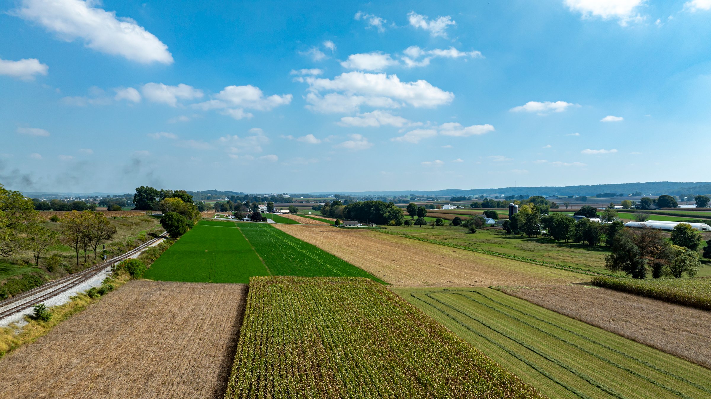 Expansive farmland showcases a patchwork of green and golden fields