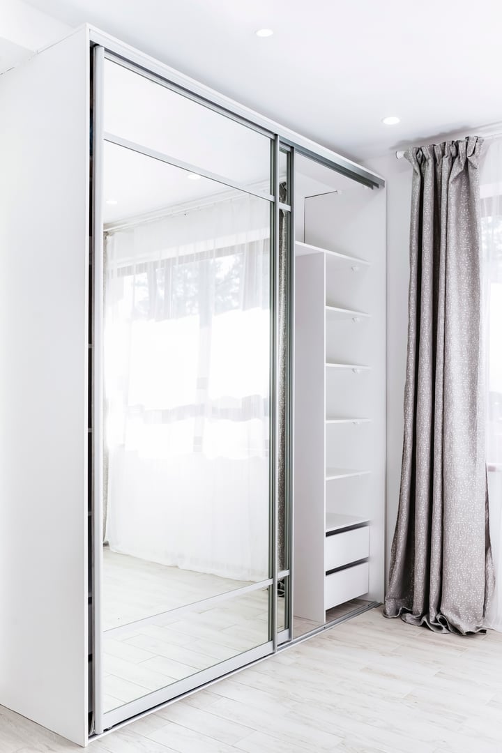 Wardrobe with mirror. Interior of modern empty wardrobe room. White closet with sliding doors