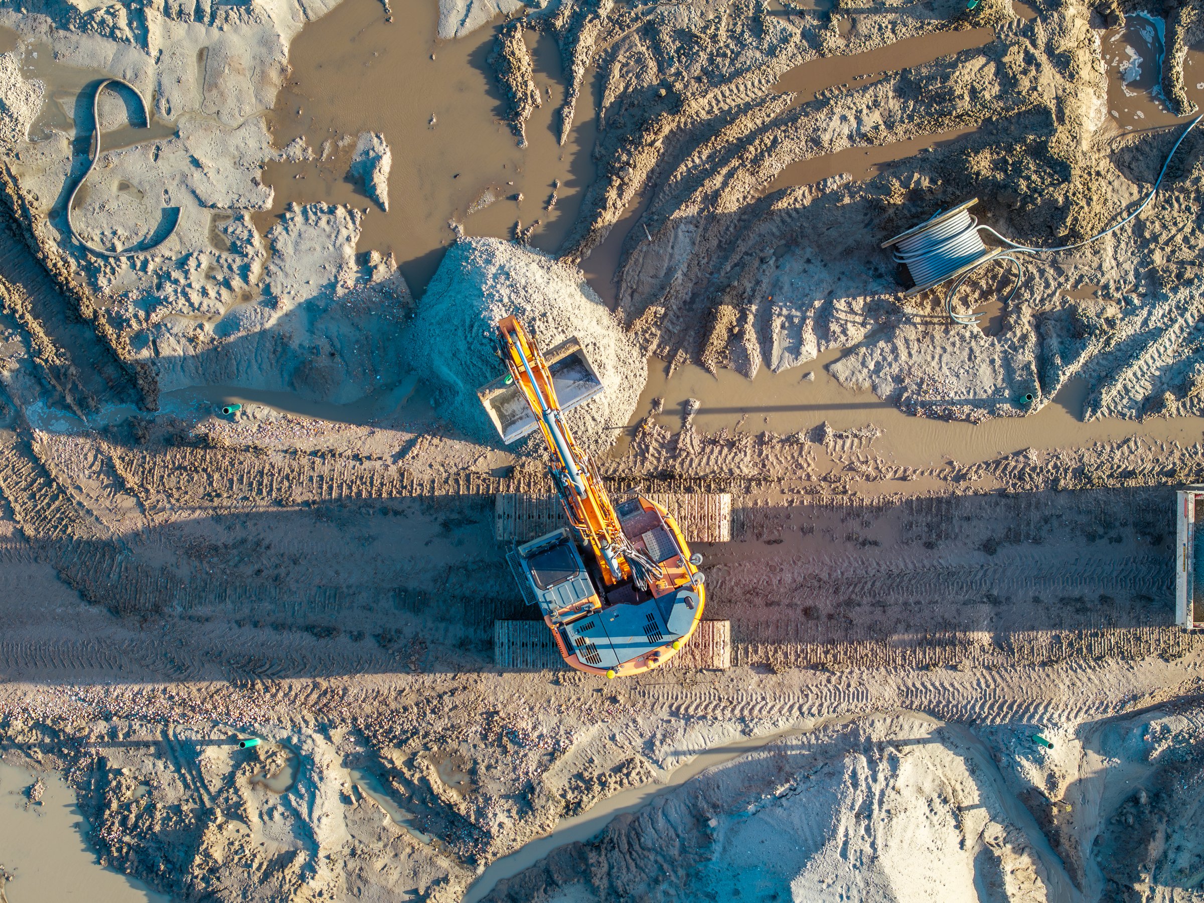 Topdown aerial of heavy machinery doing earth excavation groundworks