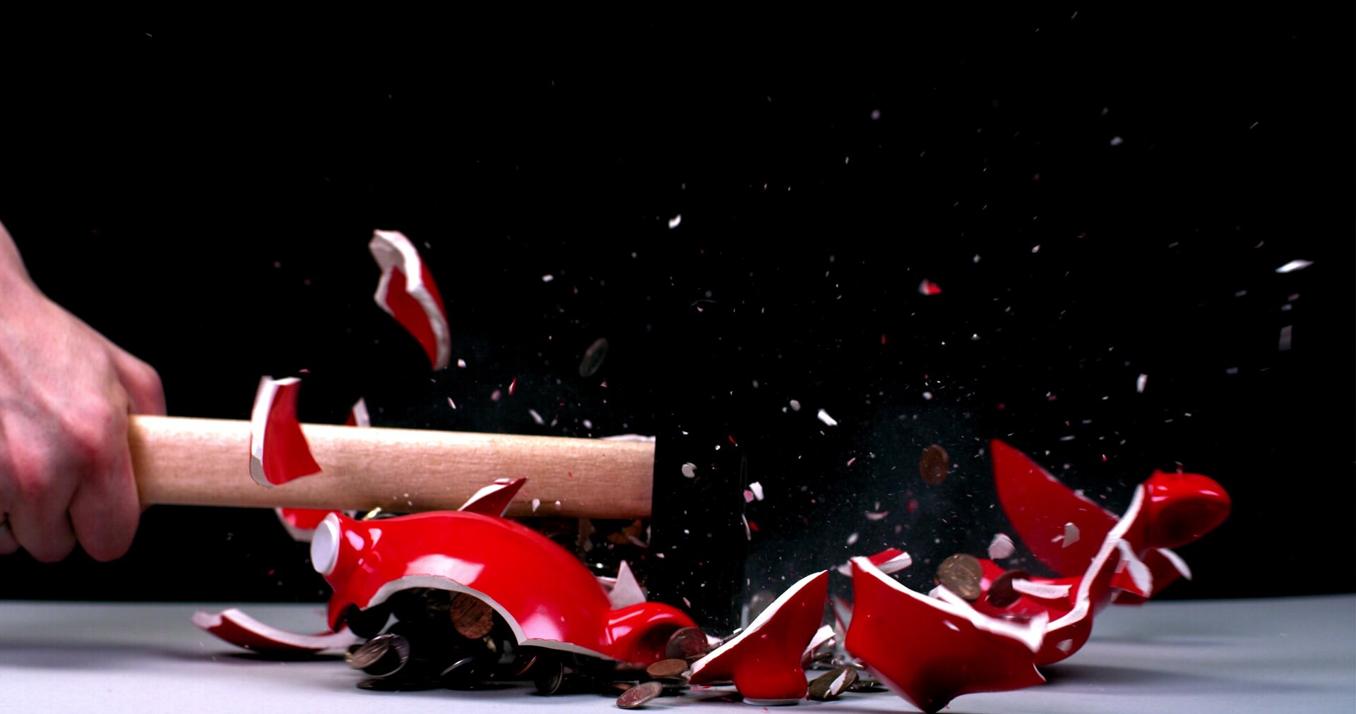 Smashing piggy bank with hammer
