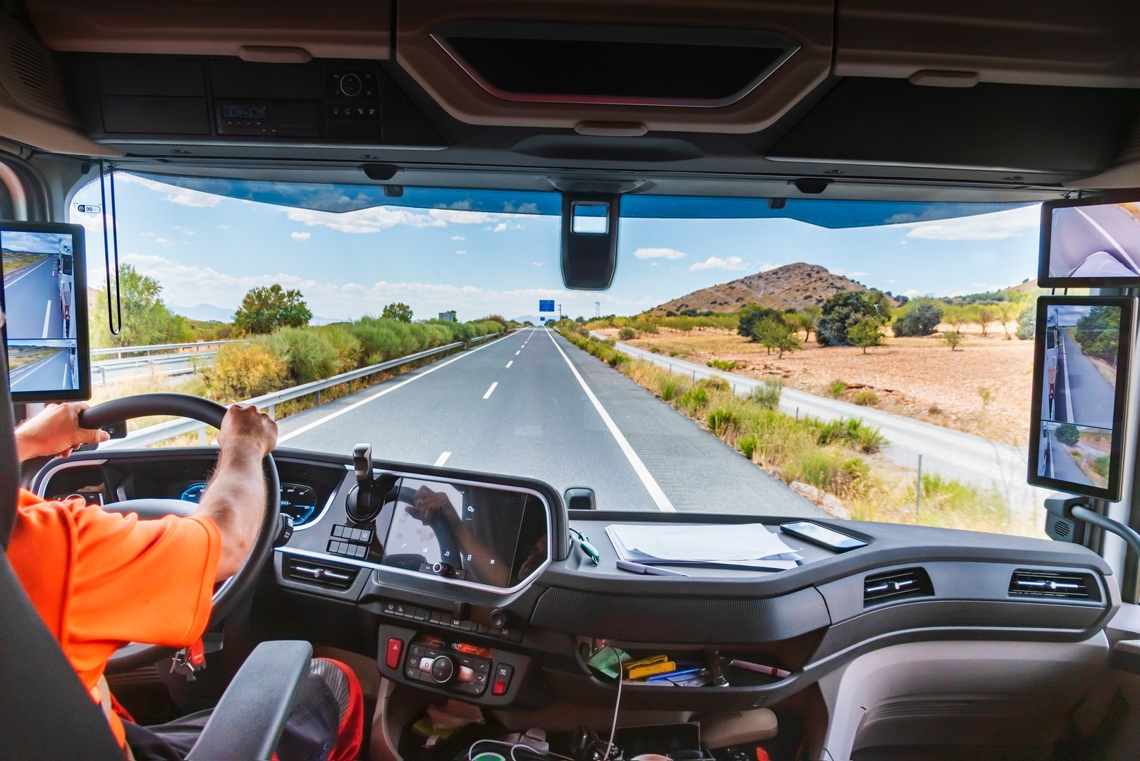 View of the interior of a state-of-the-art truck as it travels along the highway, where the driver receives all the information through the screens.