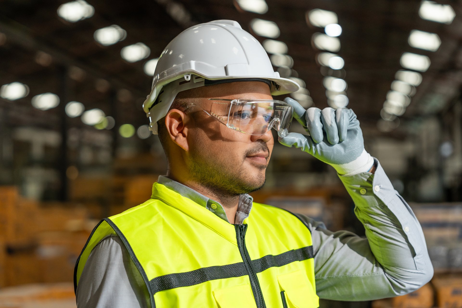 Close up technician engineer wearing and adjust protective safety glasses. Safety equipment for industry factory. Safety at work concept.