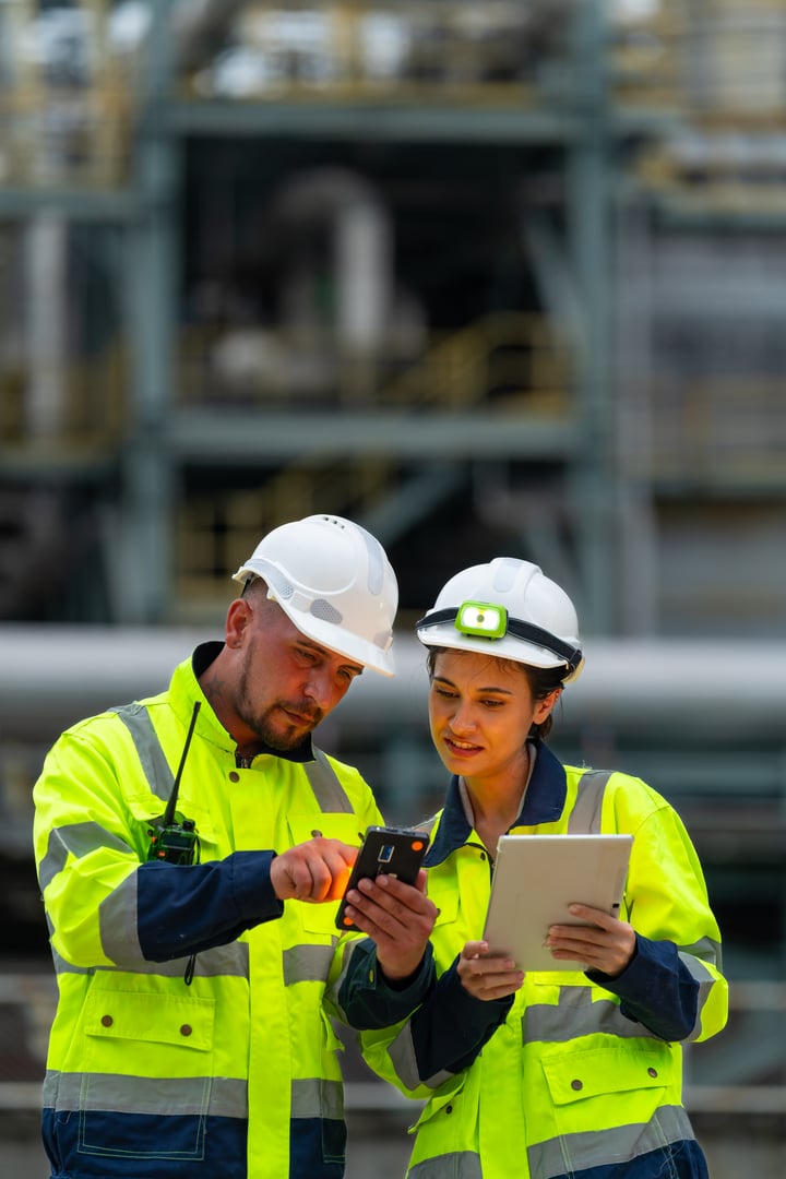 Man and woman petrochemical engineer teamwork meeting discussion at petroleum oil refinery industry area. Industrial factory technician worker working maintenance manufacturing energy power gas system.