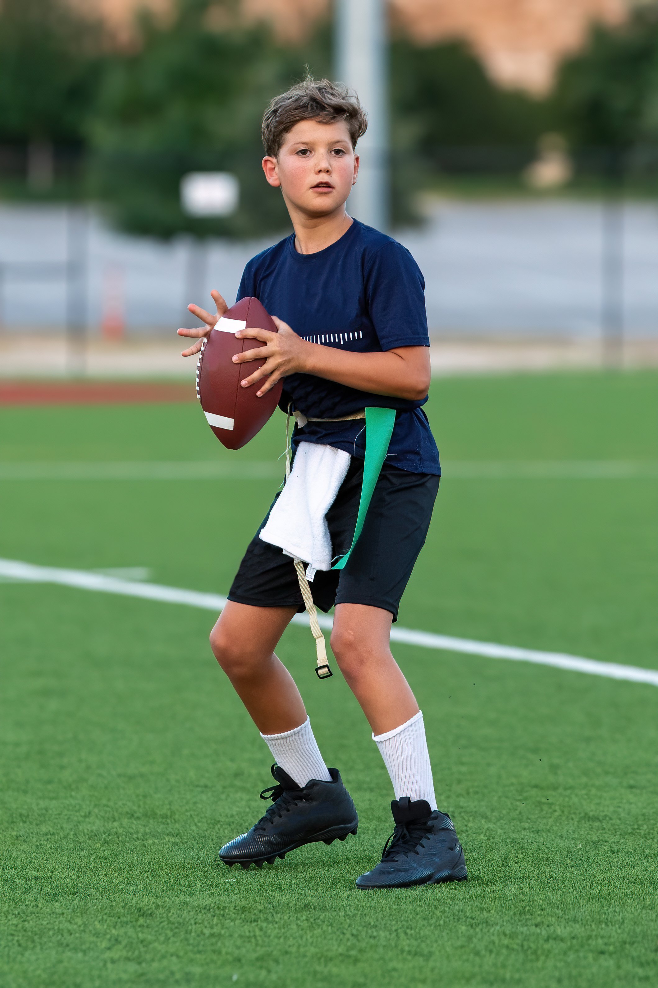 Young athletic boy catching and throwing the ball during a football game