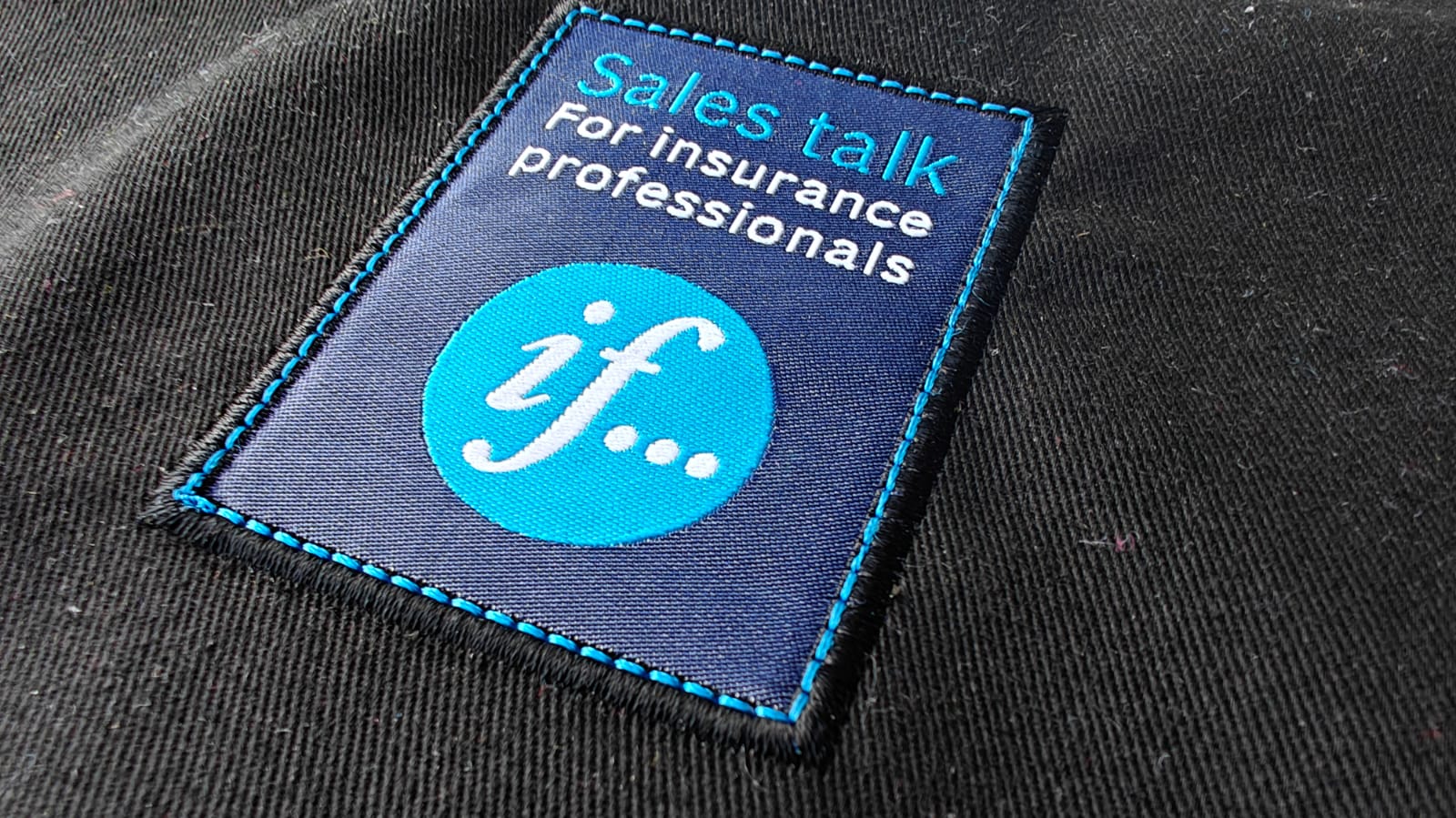 Embroidered patch on fabric with text Sales talk for insurance professionals and a logo with if... in a blue circle.