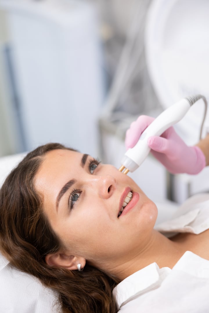 Face of relaxed young woman having radiolifting of her face by means of apparatus for aesthetic procedures