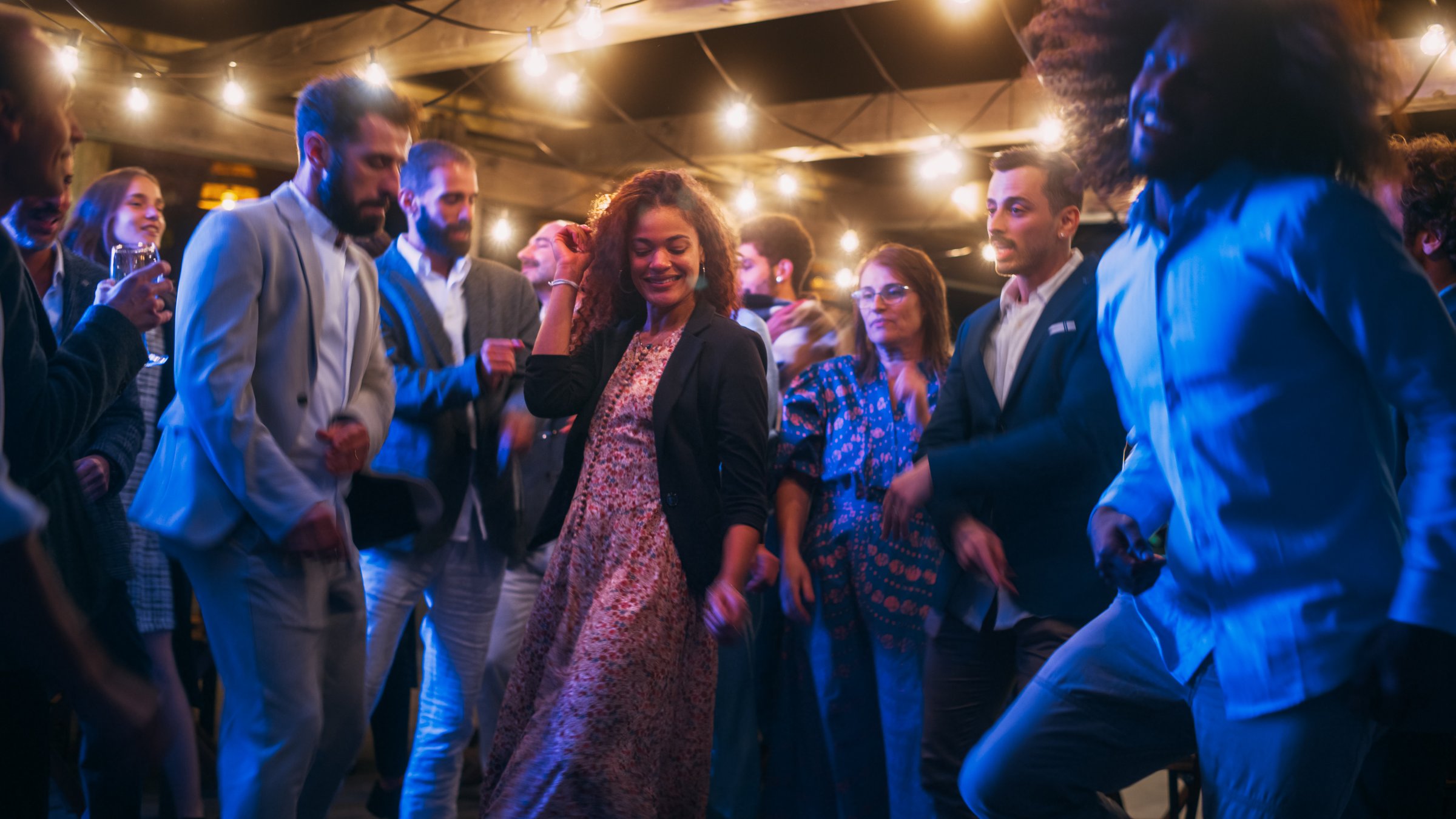 Beautiful Carefree Friends are Dancing Together and Celebrating an Evening Event at a Party . Diverse Multiethnic Young Adult People Have Fun at a Corporate Party in a Restaurant.