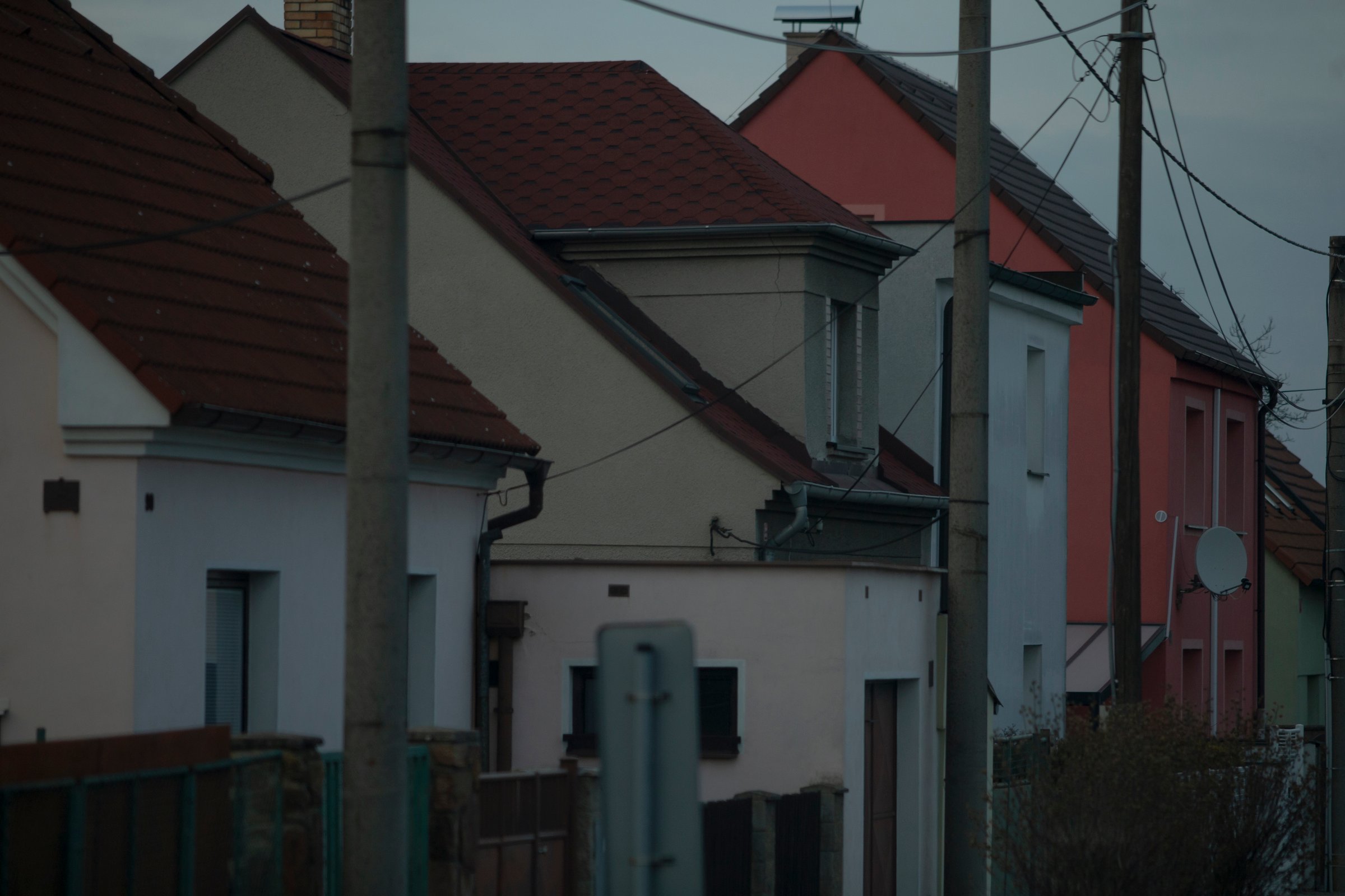 In a tranquil residential neighborhood, youll find a variety of colorful houses and utility poles lining the streets