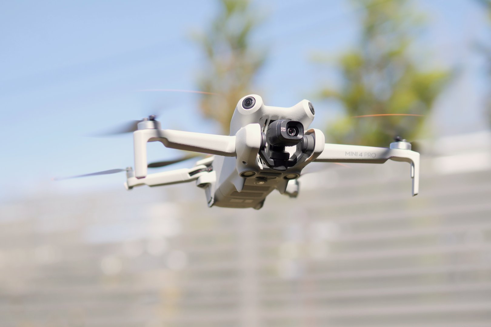 DJI Mini 4 Pro micro drone frontal view while hovering in midair at 1.20m after launch.