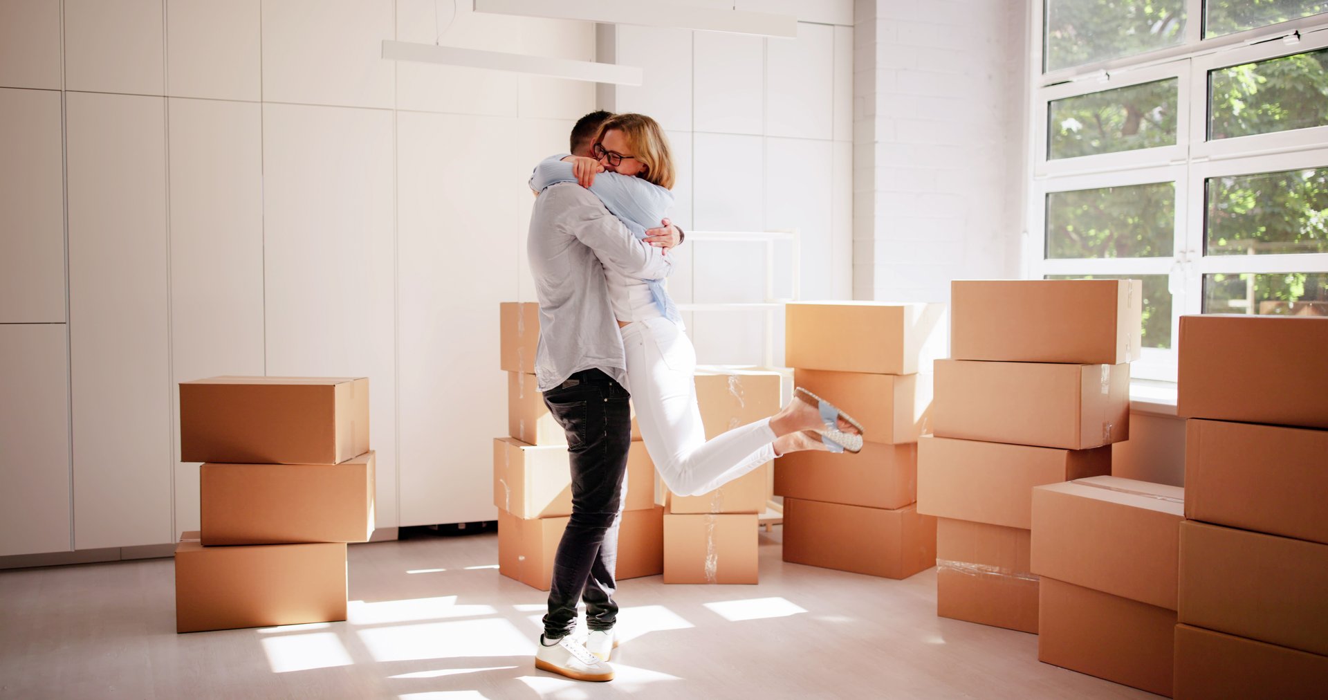 Excited Young Family Buying Their Dream Home, Celebrating with Joyful Move-In Day in White Packed House Boxes