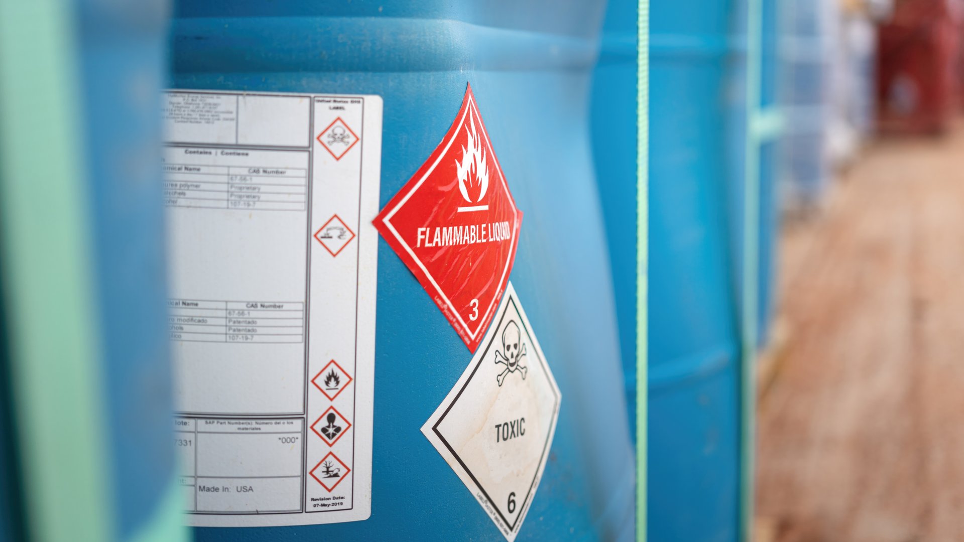 Flammable liquid warning sign on the chemical containment gallon. Industrial safety sign on the object, close-up with selective focus.