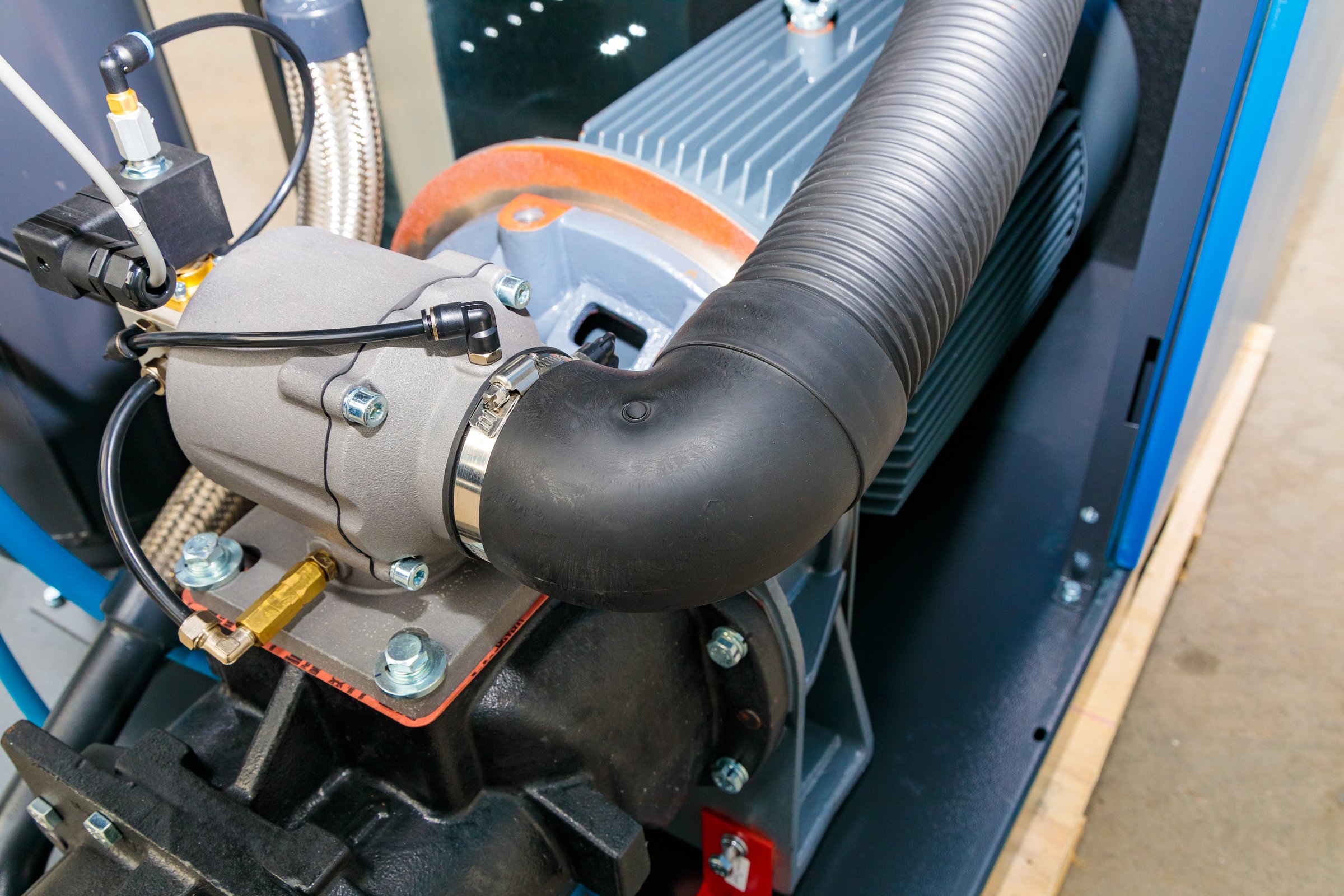Close-up of an industrial air compressor showing various components, highlighting its complex mechanics and robust construction