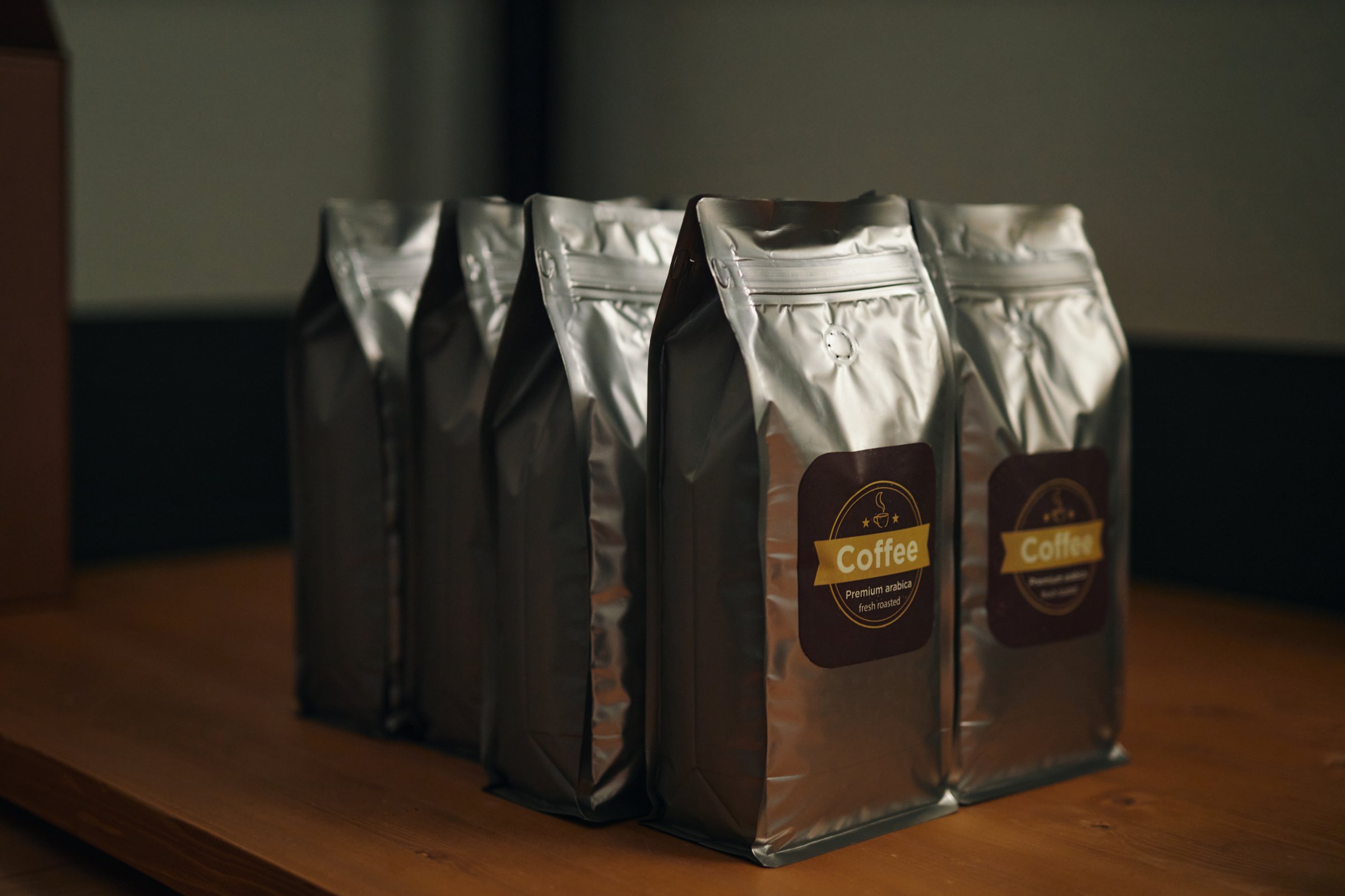 Medium close up of rectangular foil bags with labels on wooden table