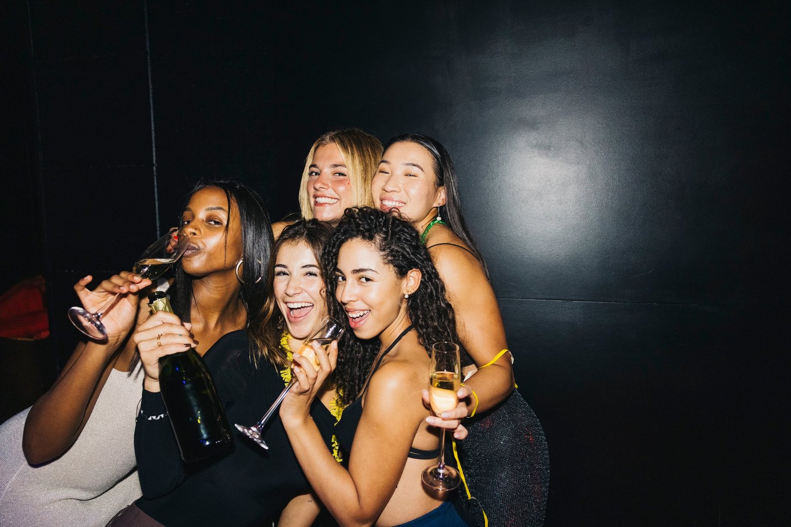A joyful group of friends enjoying a night out, celebrating with champagne at a party night out.