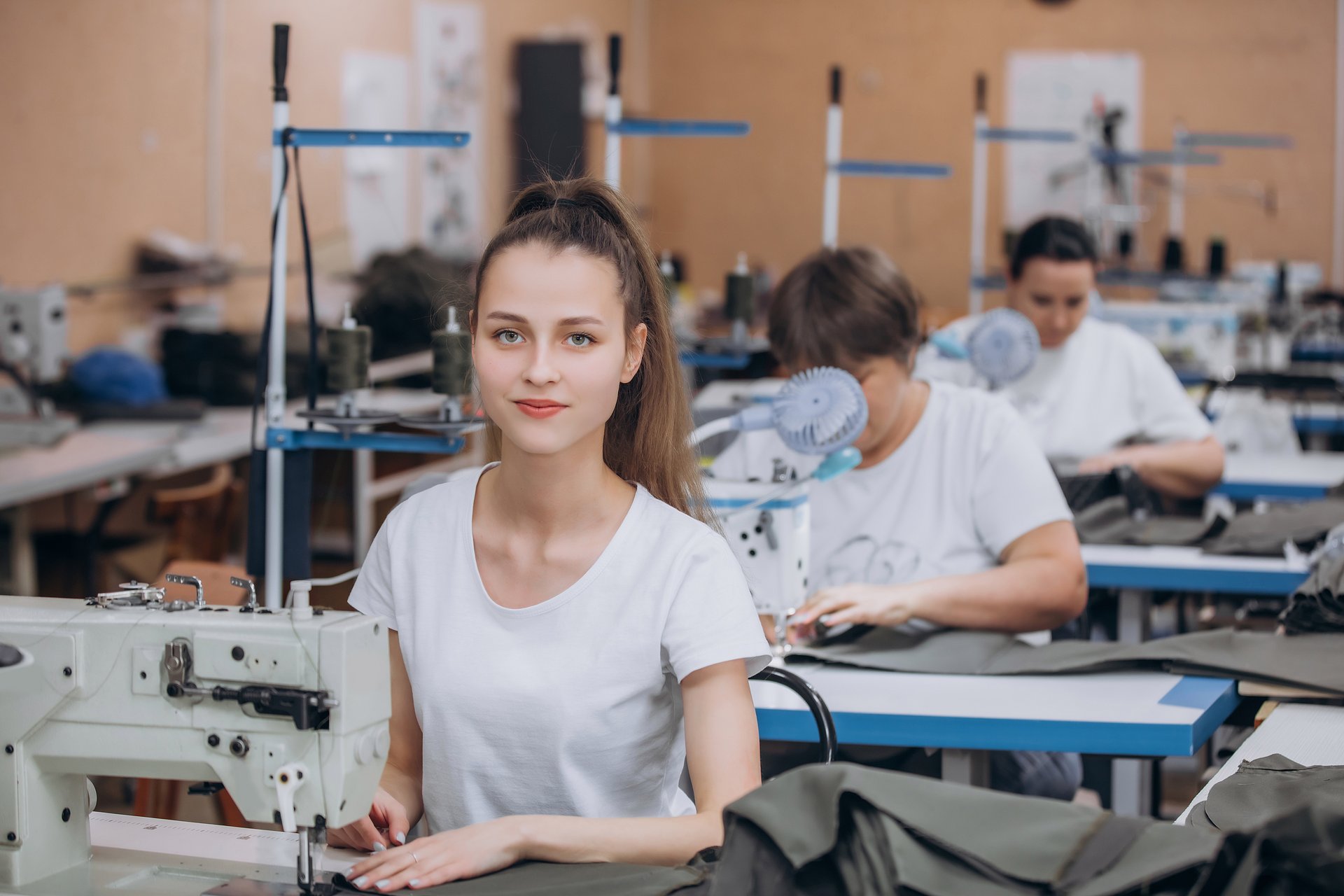 Seamstress young woman at work in a sewing workshop, small business