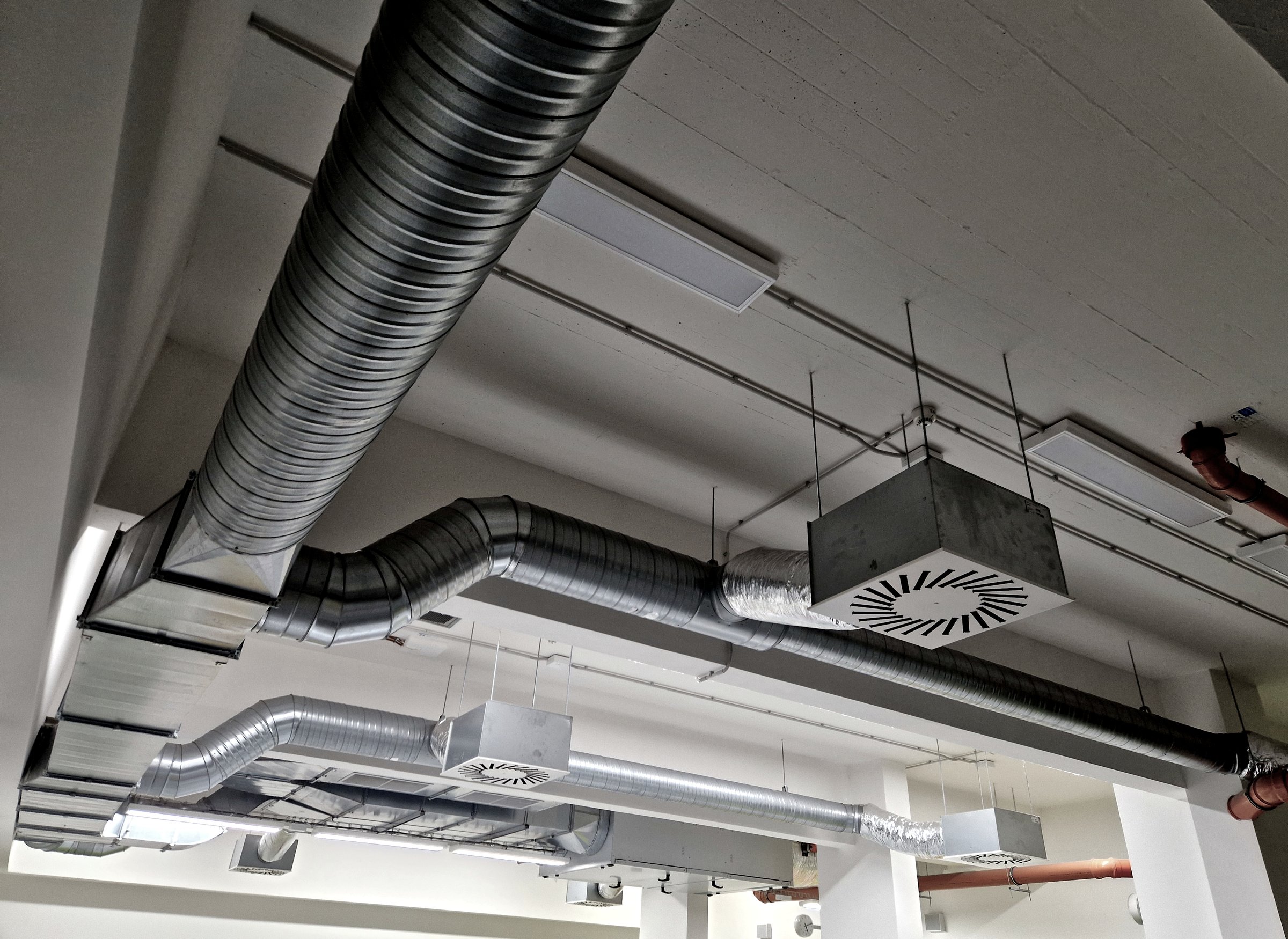The photo shows an industrial HVAC system, including ductwork and air filters. The system provides air supply and exhaust, conditioning, and distribution throughout the building.hepa, recuperation