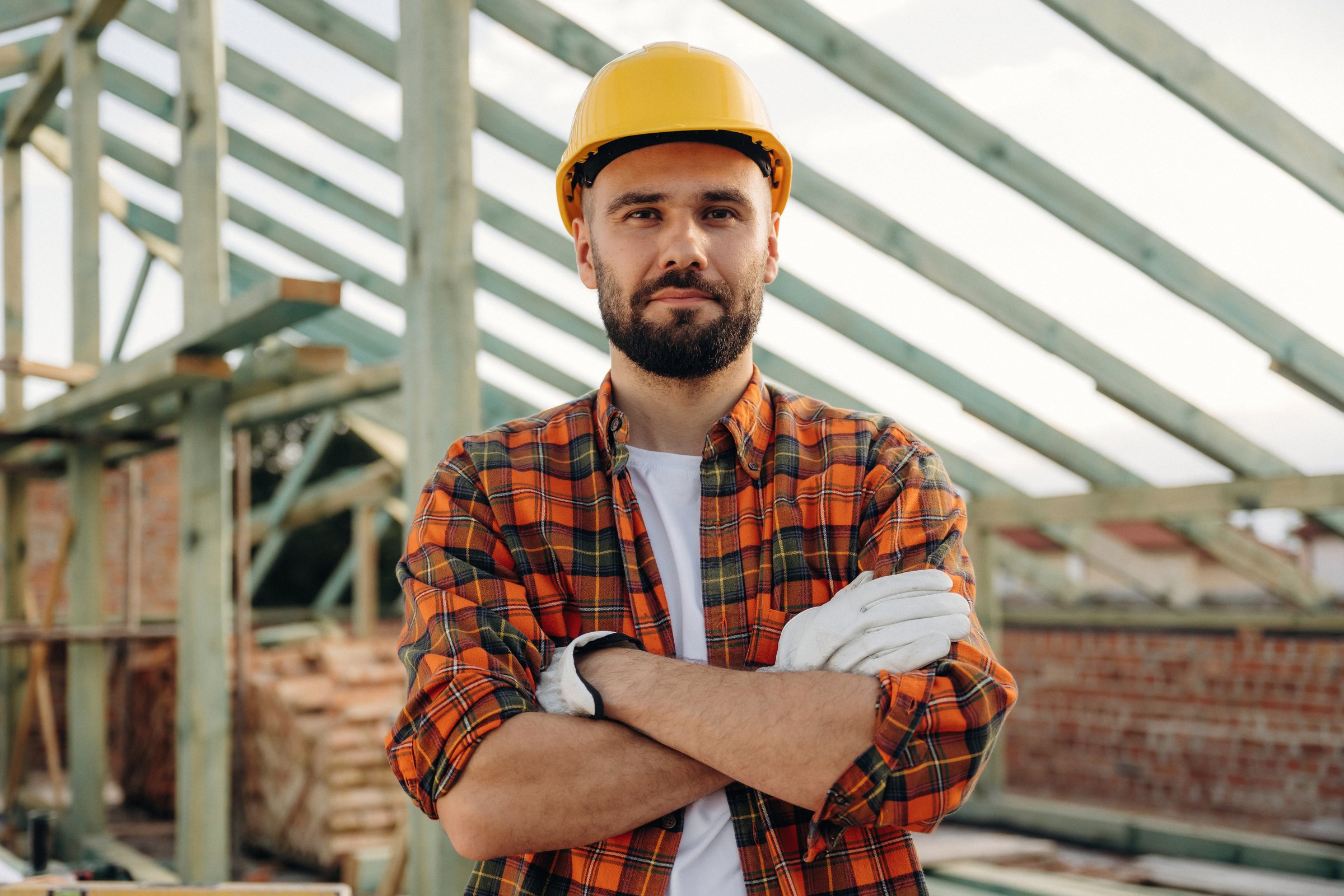 Handsome man, portrait. Construction worker is on the roof of a house.