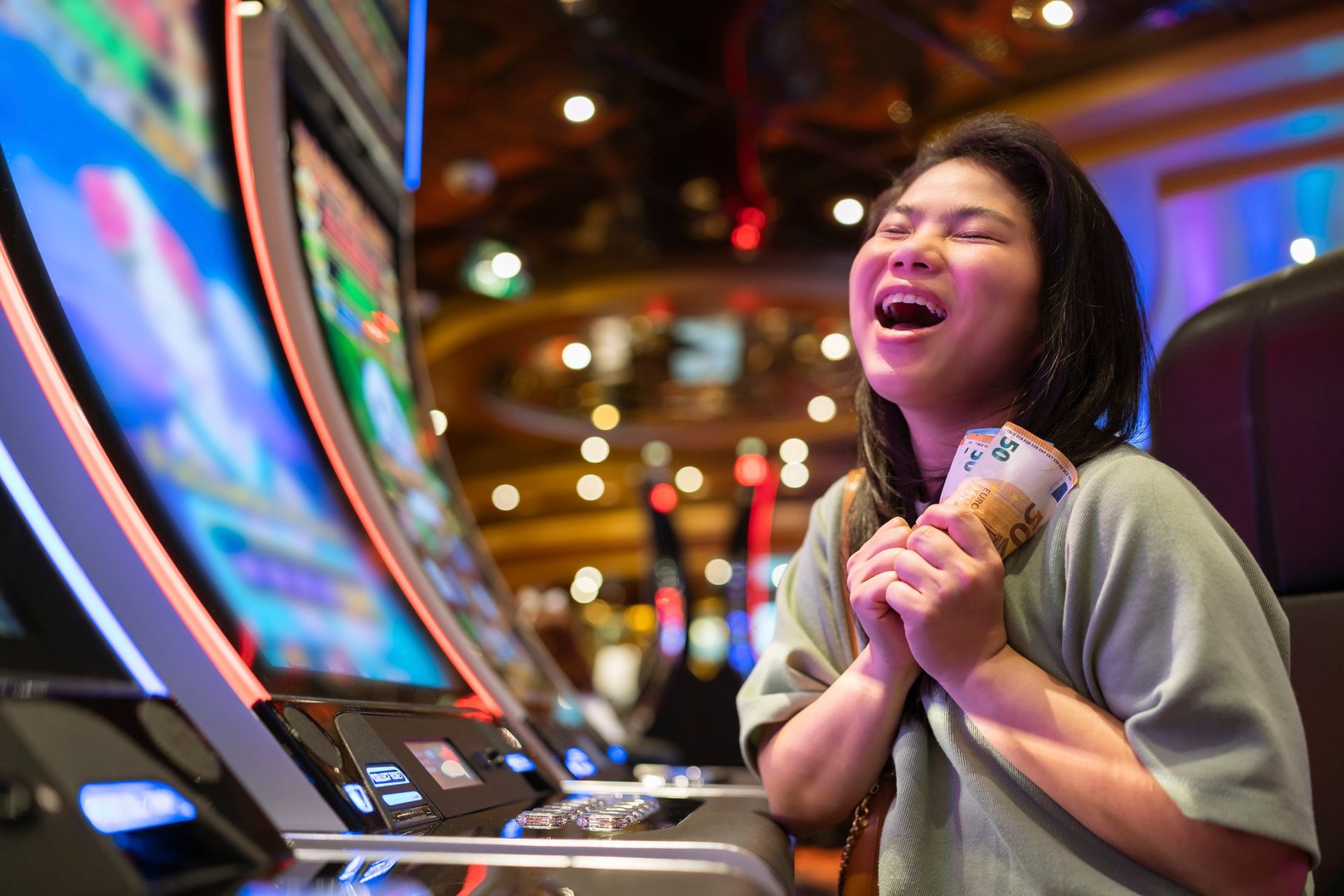 exited asia female woman slot machine gambling cheerful smile hand pressing bet button in casino club entertainment concept,exited asian woman hand play slot machine in casino hotel