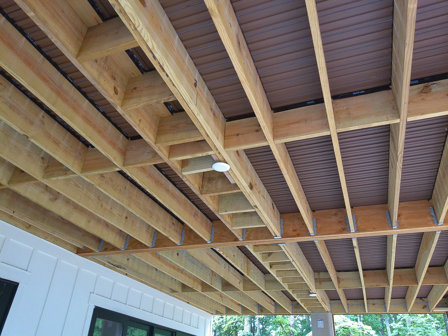 Wood framing under an outdoor deck showcasing construction expertise