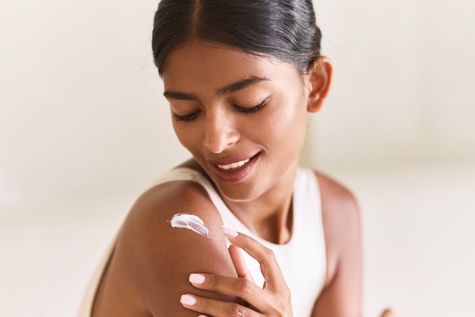 Woman Skincare Beauty. A Woman Gently Applies Cream to Her Shoulder, Embracing Self-Care and Serenity. Perfect for Concepts of Skin Nourishment, Personal Care, and Relaxation.