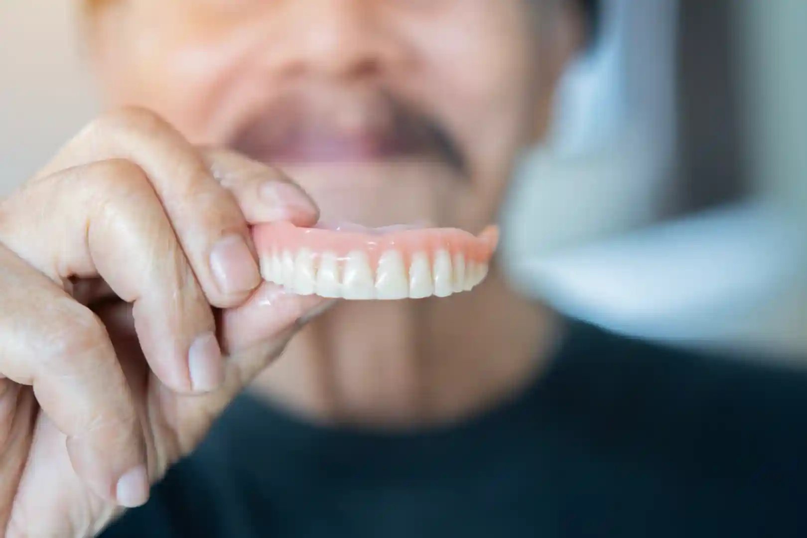 Happy elderly patient demonstrating complete and partial dentures during prosthetic dental consultation - custom denture fitting process and dental prosthetics education at Murwillumbah Dental clinic for tooth replacement solutions