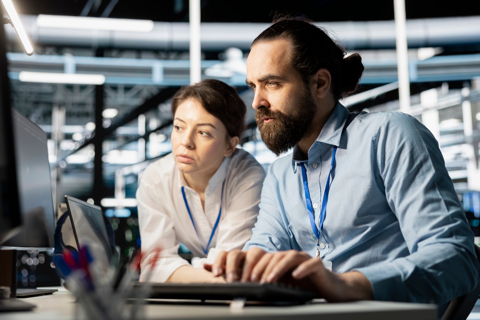 Data center coworkers doing brainstorming, running diagnostic scripts on computer, examining hardware. Server room employees talking, working together to evaluate performance metrics
