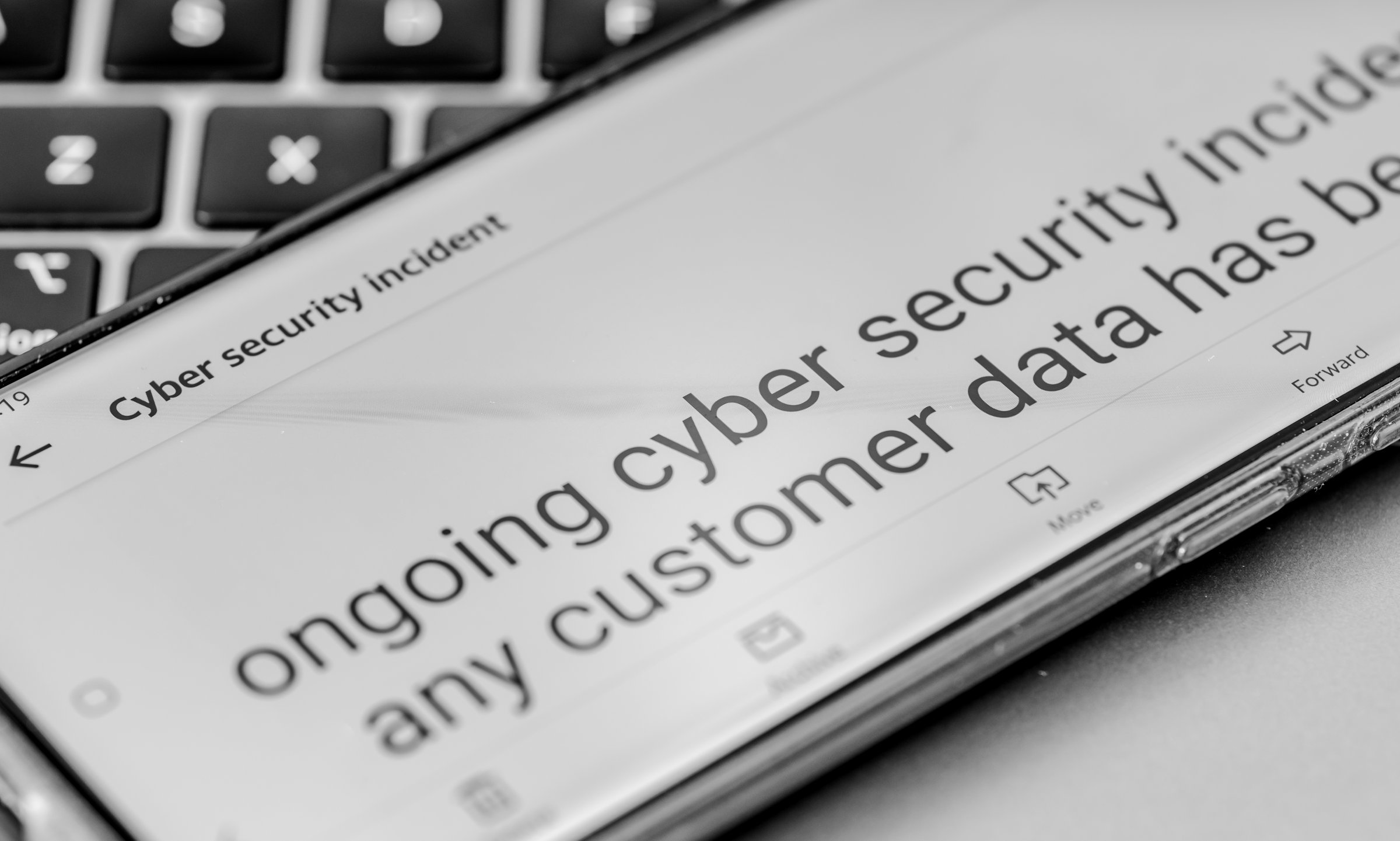 Close up of a message on a mobile phone from a company informing its clients of an ongoing cyber security incident.