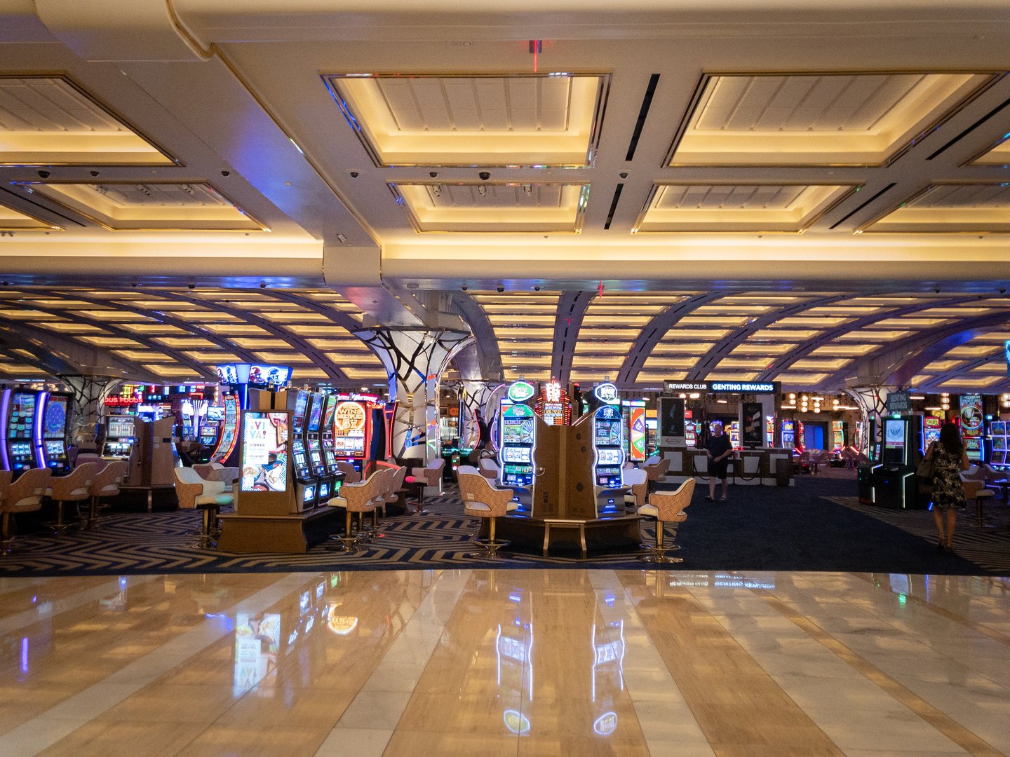 Las Vegas - August 19, 2024: Picture of slot machines in the casino of Resorts World Las Vegas. Resorts World Las Vegas is a resort and casino on the Las Vegas Strip in Winchester, Nevada, United States. It is owned and operated by Genting Group as part of the Resorts World brand. The image showcases a row of slot machines within the casino at Resorts World Las Vegas, one of the newest and most luxurious destinations on the Las Vegas Strip. The casino floor is alive with vibrant lights, flashing screens, and the sounds of electronic gaming machines. Patrons are seated at the slot machines, engrossed in gameplay, embodying the thrill and excitement associated with gambling. Resorts World Las Vegas offers a modern take on the classic Las Vegas casino experience, blending state-of-the-art technology with opulent design. The photograph captures the essence of Las Vegas as a global entertainment capital, renowned for its nightlife, casinos, and leisure activities. The casino environment reflects the city's allure for tourists seeking gaming experiences, luxury accommodations, and high-end entertainment options.