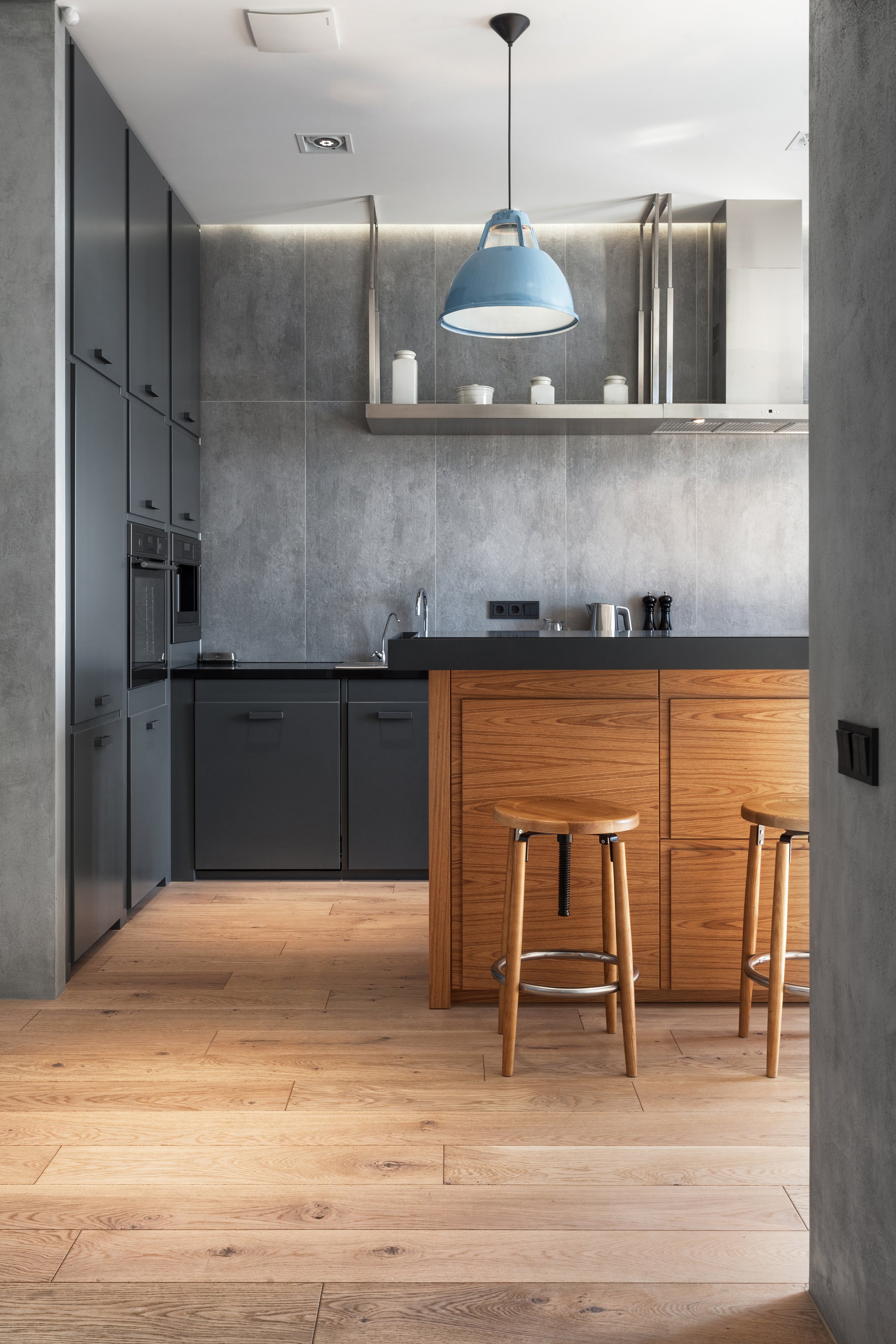 Vertical shot of elegant kitchen with gray cabinet, wooden table and chairs on parquet. Stylish interior design in modern apartment. Tidy, neat storage concept