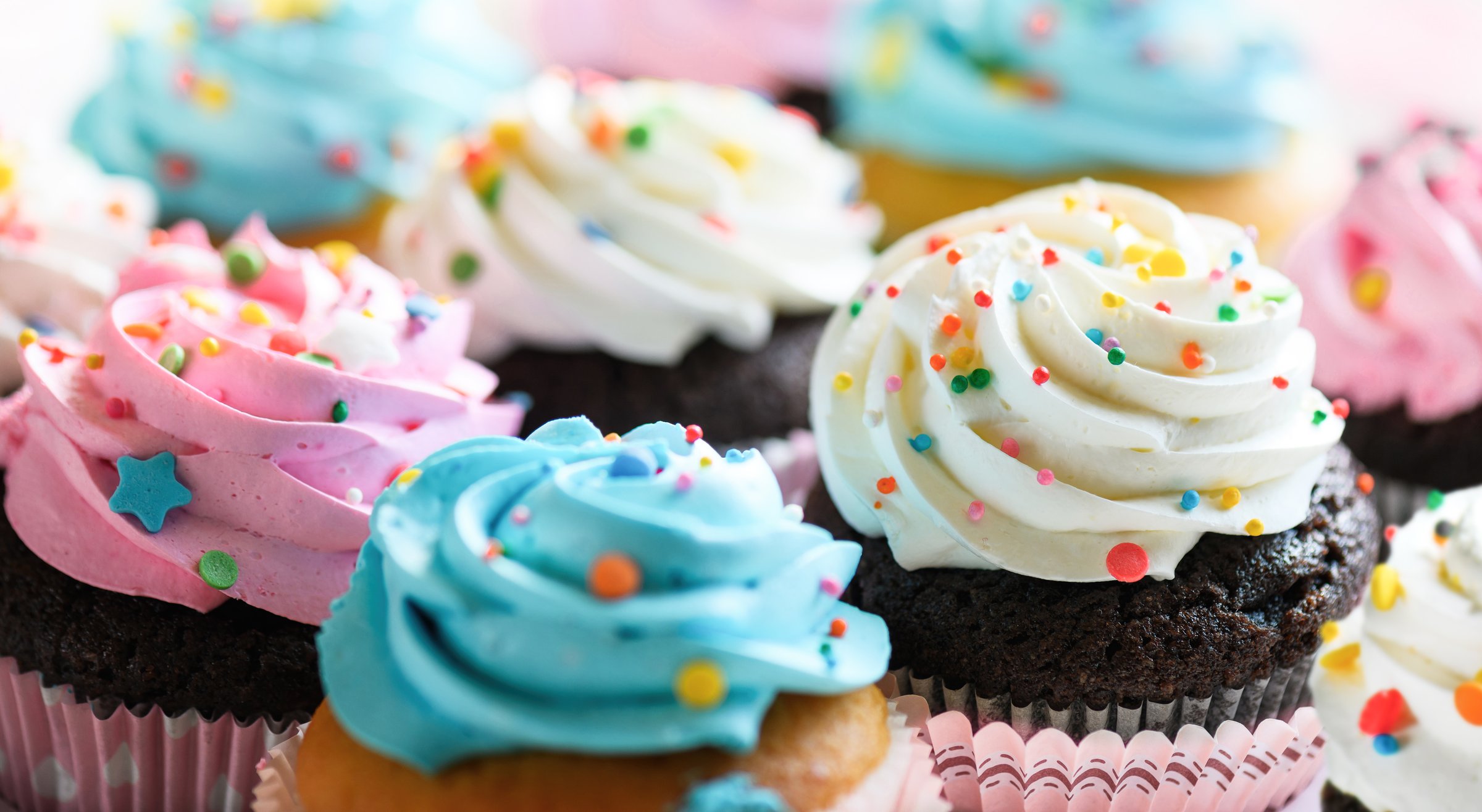 Various cupcakes with pink white and blue cream. Cupcakes for party, birthday. Selective focus, shallow DOF.