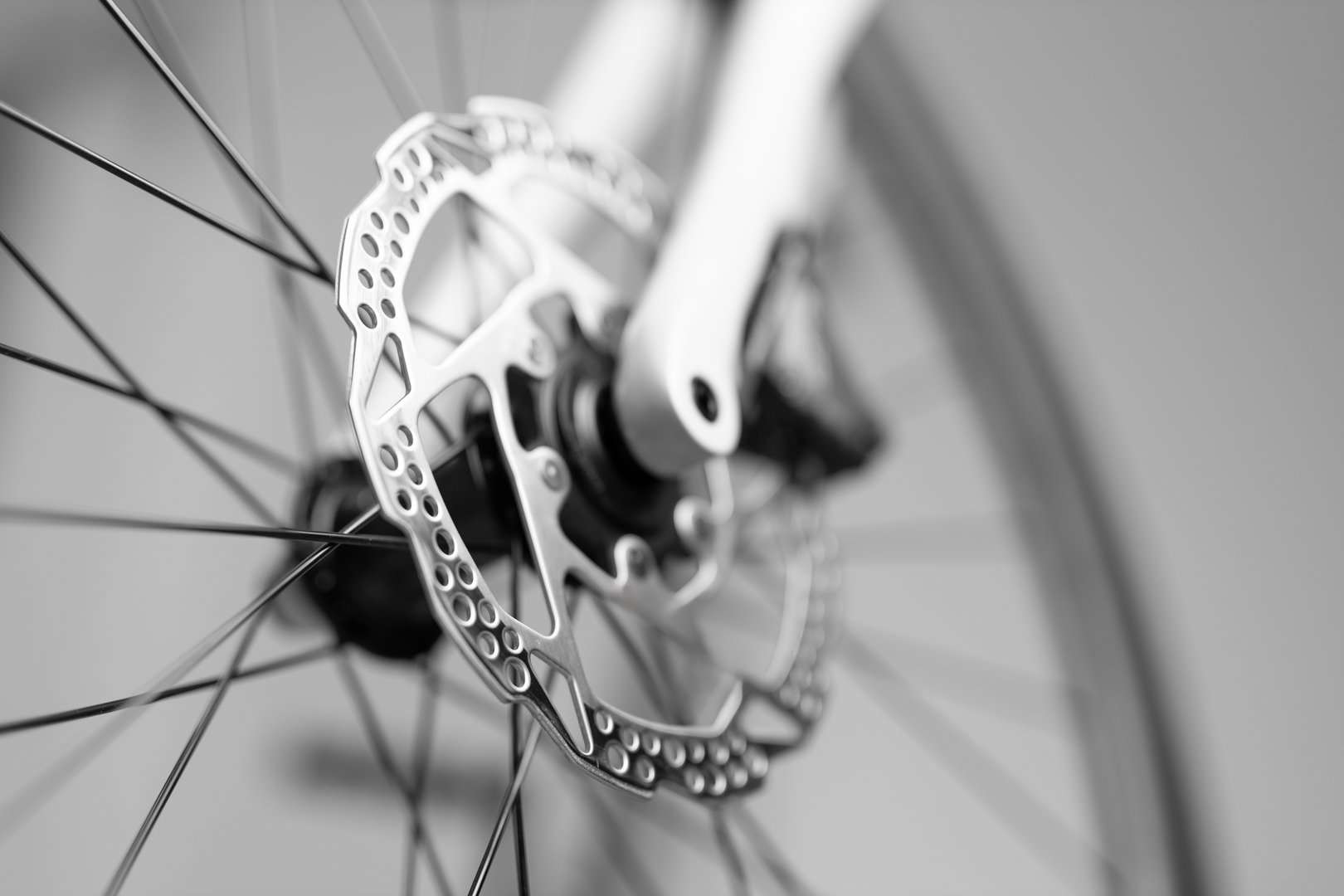 A close up of a bicycle's rear wheel with a shiny silver disc attached to it