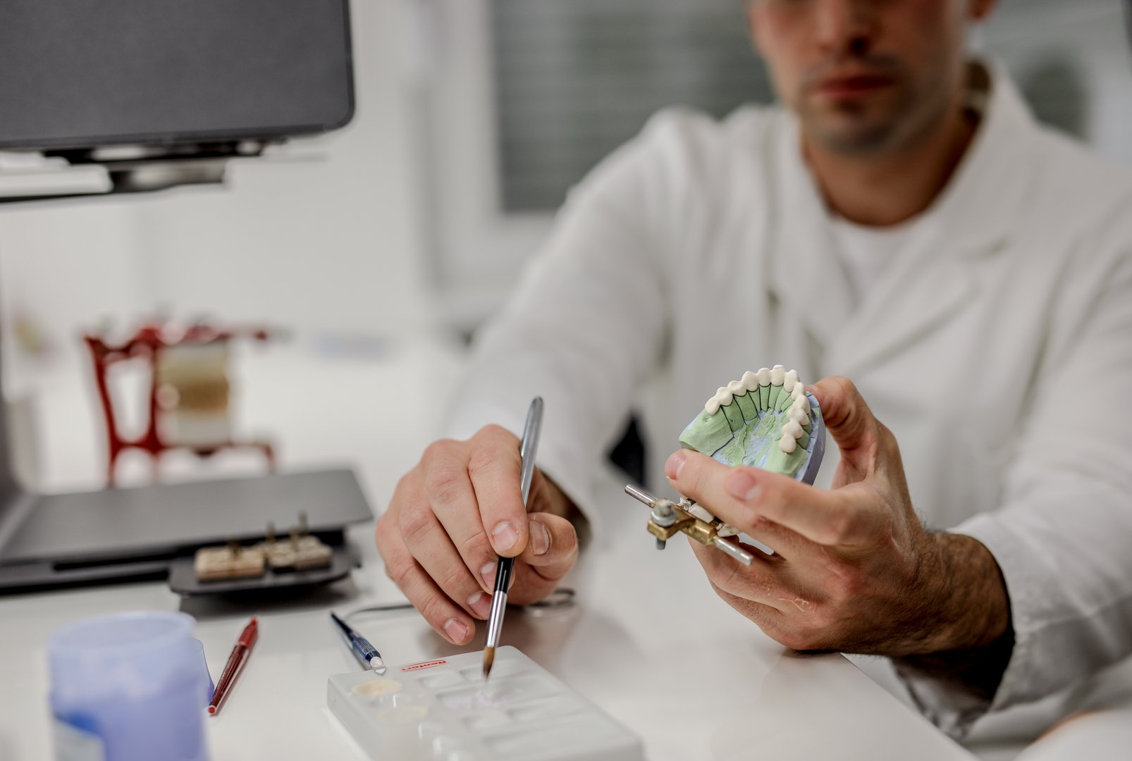 Young man working on ceramic dental implant.