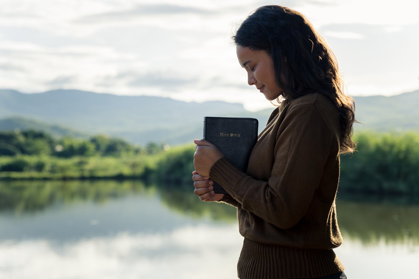 Young woman praying to god with the bible, Christianity, Concept of faith for god and teachings from the Bible.