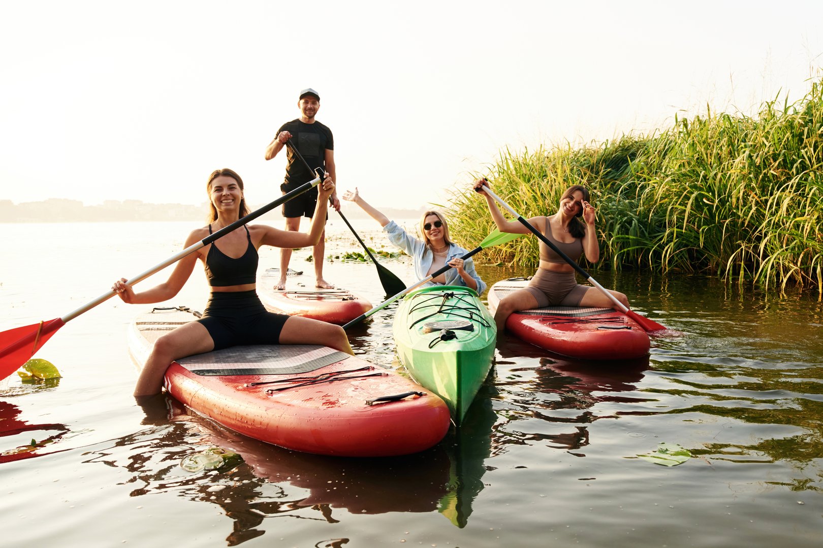 Women and man. Friends are together on sup boards on the lake.