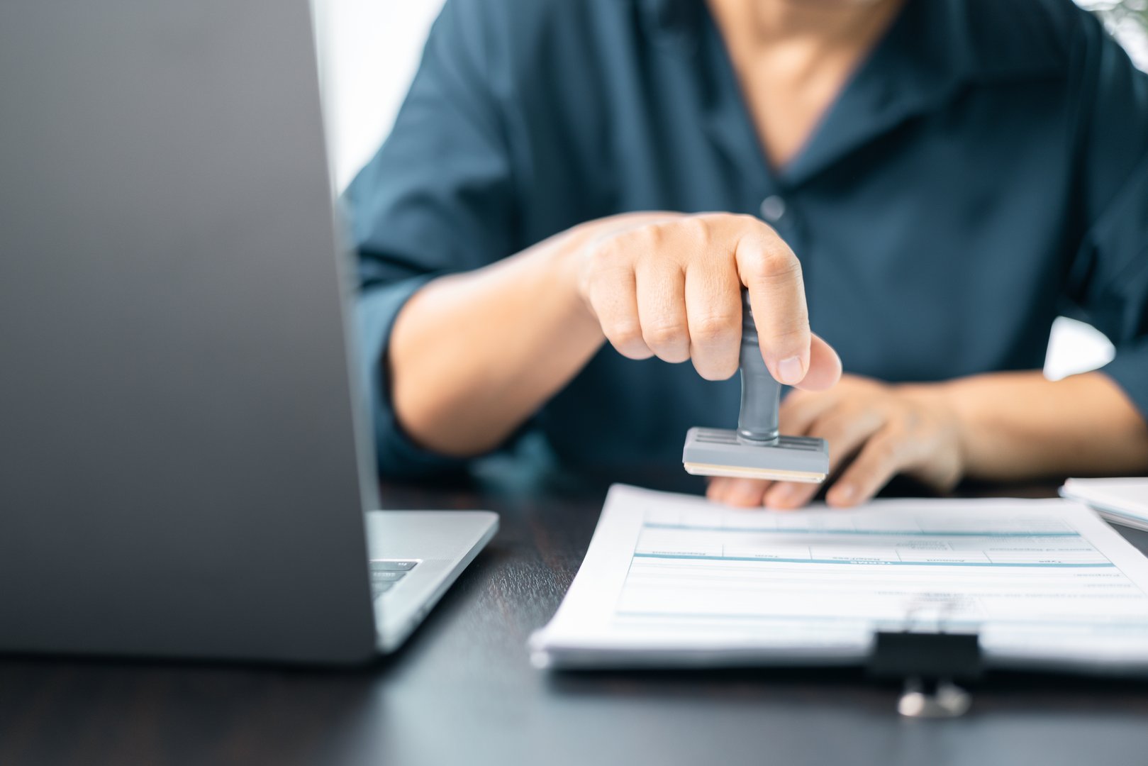 Banking officer stamped the document to approve the loan, finalizing contract and solidifying the finance agreement, fundamental concept in business transactions. approve, loan, stamp, business.