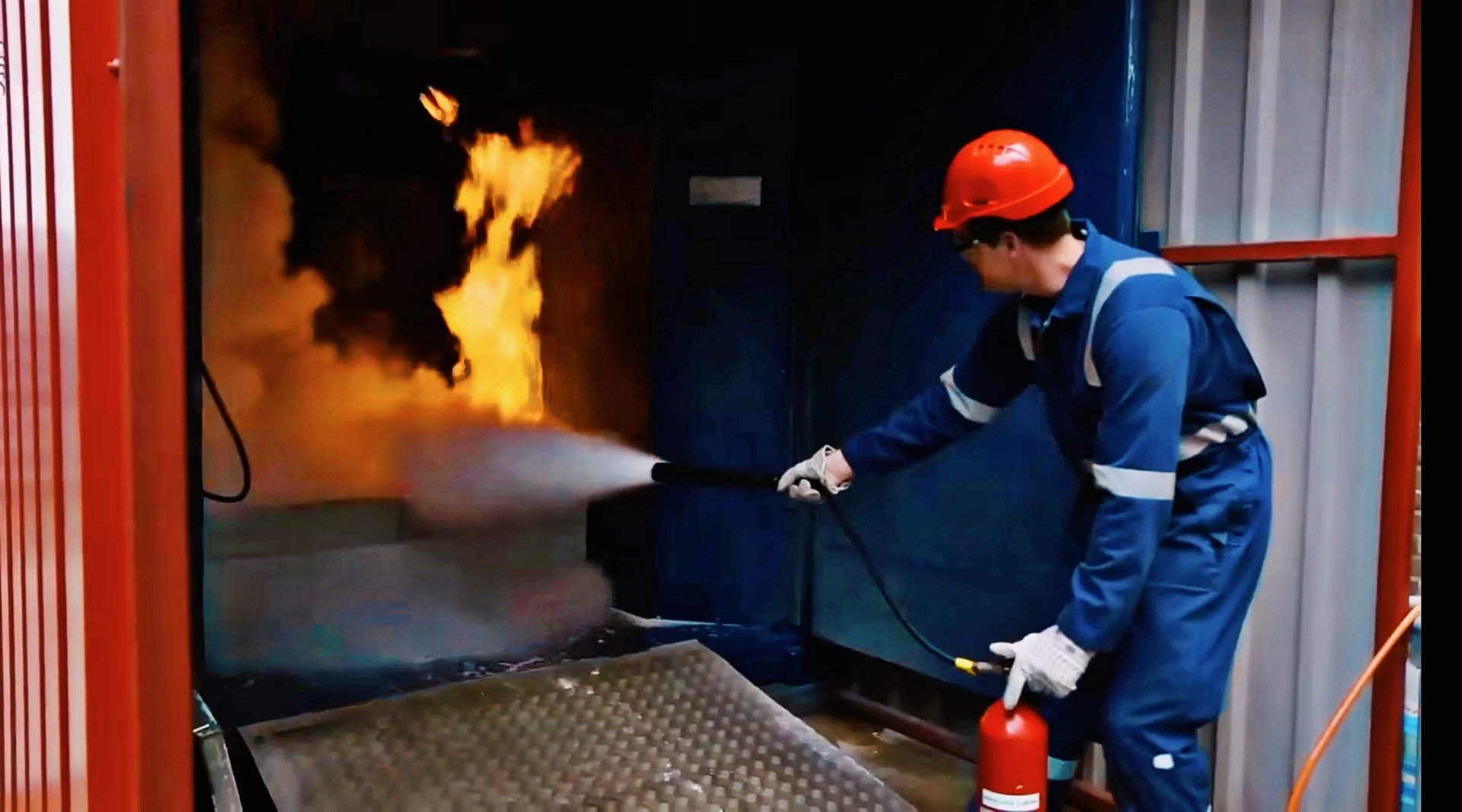 Delhi, India-September 2nd,2025: Industrial worker wearing protective gear and hard hat extinguishes flames during a workplace fire safety training exercise.