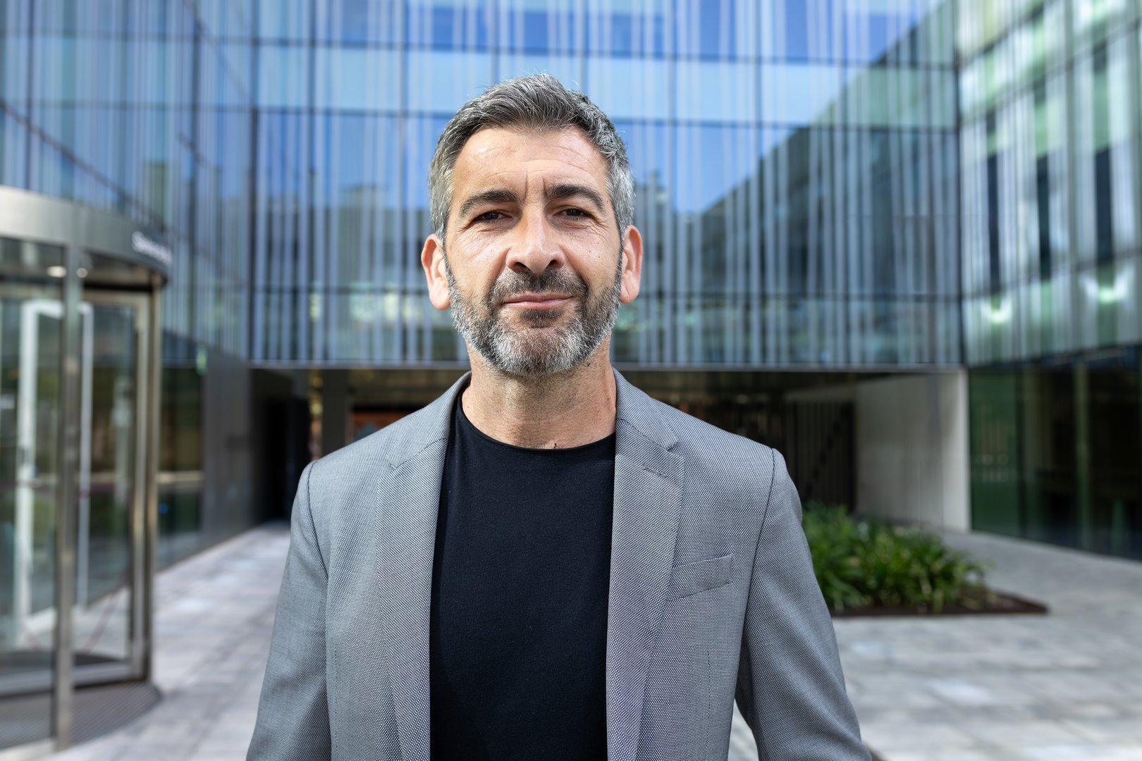 Confident businessman smiling outside office building in modern financial district