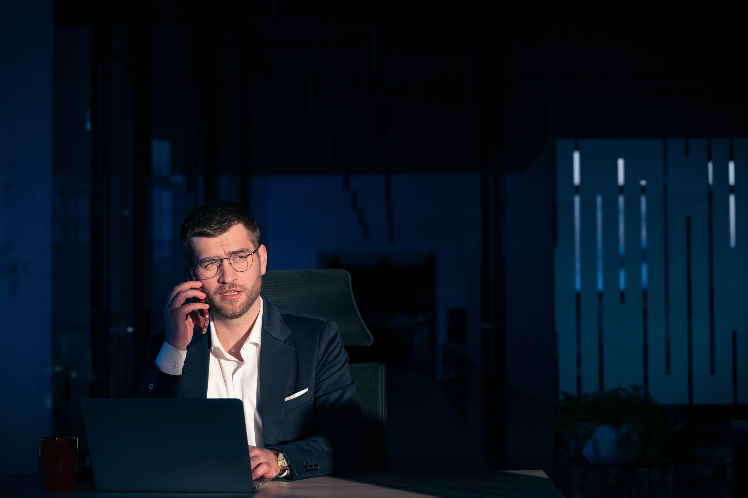Business executive talking on phone in dark office