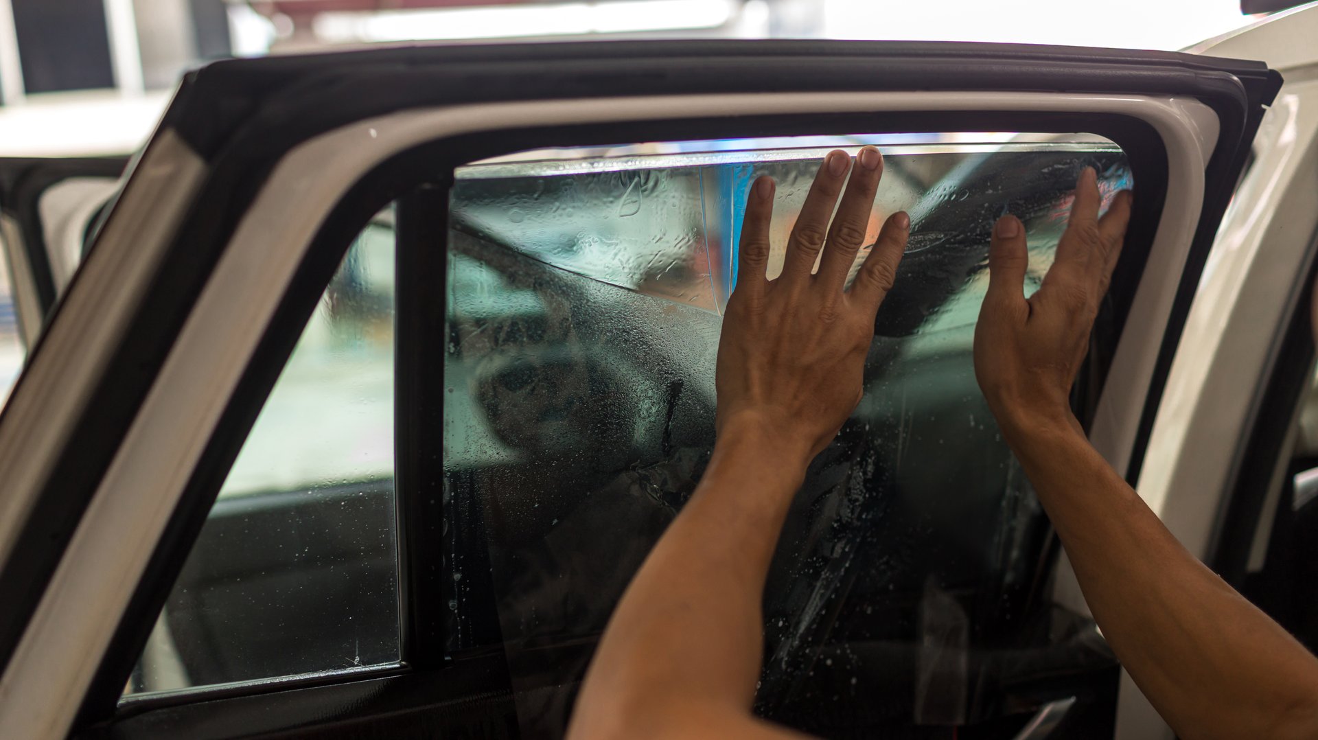 Technician Installing car window tint. Car window tinting series. Car window tinting specialist install car film windscreen.