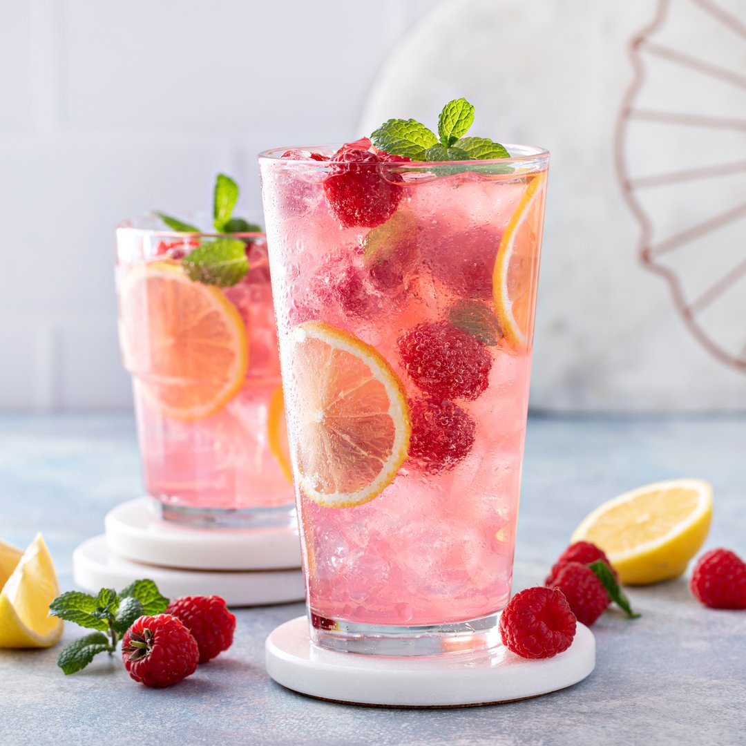 Spring or summer refreshing cold cocktail or mocktail with berries and lemon, raspberry lemonade