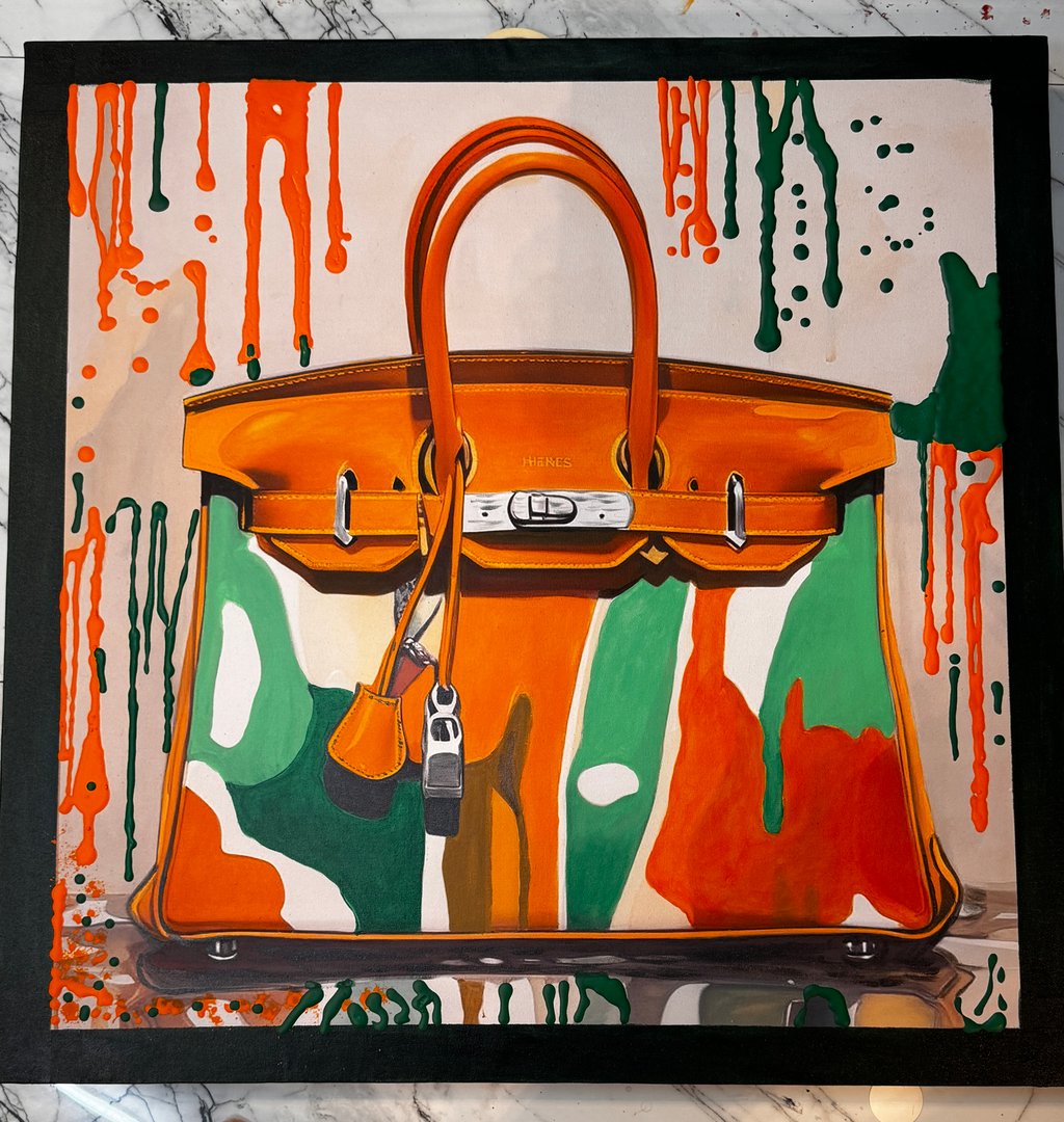 Colorful handbag with abstract orange, green, and white design on a marble surface, featuring a metal lock.