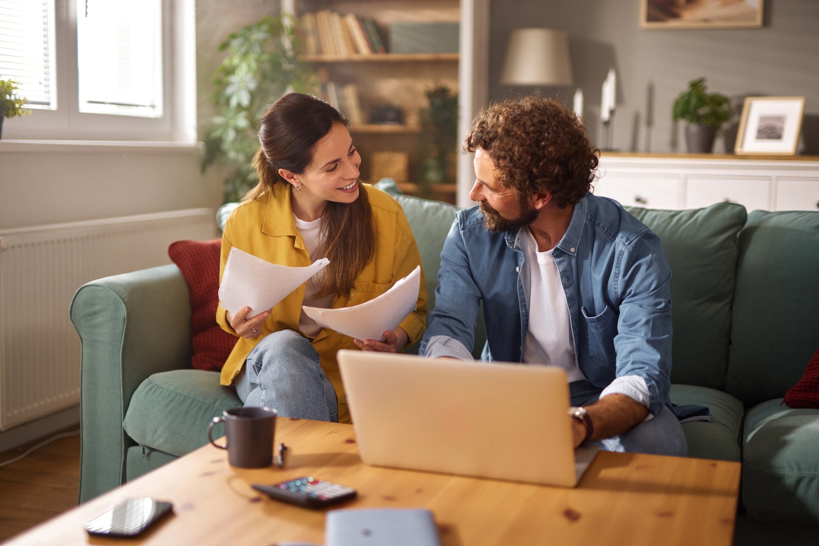 Young couple reviewing their life insurance policy and managing finances using a laptop at home
